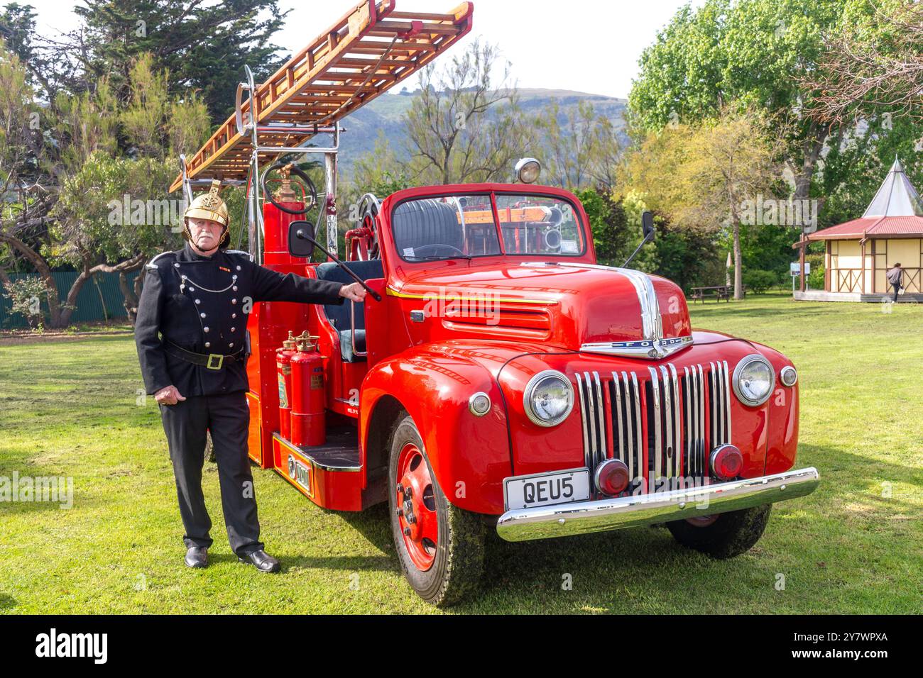 Feuerwehrmann mit einem alten Ford Feuerwehrauto im Ferrymead Heritage Park, Ferrymead, Christchurch (Ōtautahi), Canterbury, Neuseeland Stockfoto