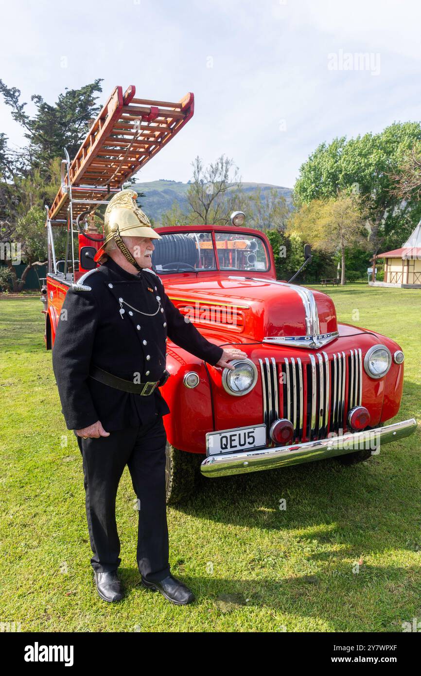 Feuerwehrmann mit einem alten Ford Feuerwehrauto im Ferrymead Heritage Park, Ferrymead, Christchurch (Ōtautahi), Canterbury, Neuseeland Stockfoto