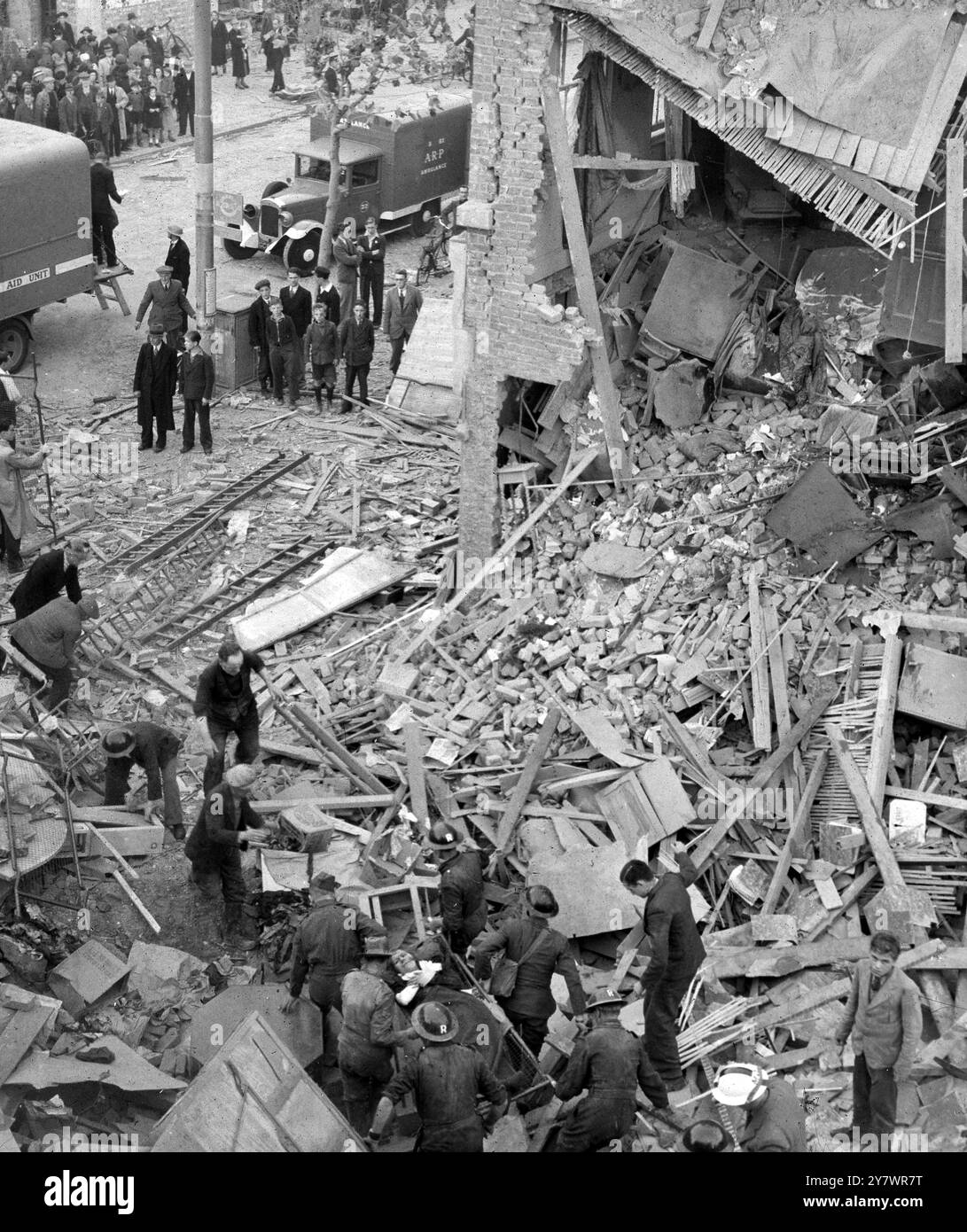 Frau, die von der ARP während des Zweiten Weltkriegs vor Bombenschäden in einer Fabrik gerettet wurde, Foto von John Topham 1940. Veröffentlicht am 20. Oktober 1940 auf der Titelseite des Sunday Pictorial. John Tophams zeitgenössische Beschreibung über die Bombenangriffe in Südostengland und London zu Beginn des Zweiten Weltkriegs: „Die Londoners [Londoner Zeitungen] telefonierten nachts, während die Bombenangriffe noch andauerten. Wir mussten raus. Die Leute hielten uns für verrückt. Wir waren immer in Gefahr, dass eine Hauswache eine Kugel in das Auto wirft. Sie würden uns alle 100 Meter oder so stoppen. Ich habe ein paar blutrünstige Bilder, einschließlich eines Sets davon Stockfoto