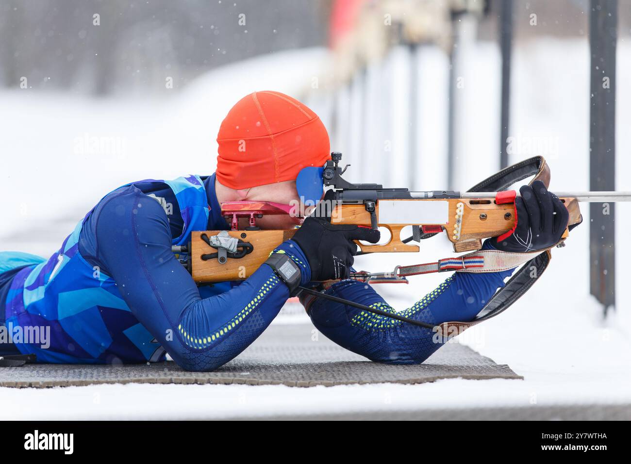 Sportlerschießen in Bauchlage auf der Strecke bei einem Biathlonwettbewerb. Stockfoto