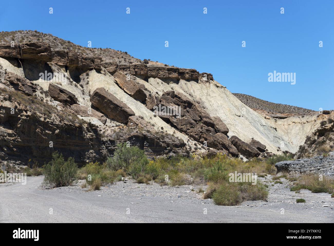 Felsen und Klippen erheben sich in einer trockenen Wüstenlandschaft unter einem klaren blauen Himmel, La Tortuga, Tabernas Wüste, Desierto de Tabernas, Schauplatz zahlreicher Filme Stockfoto