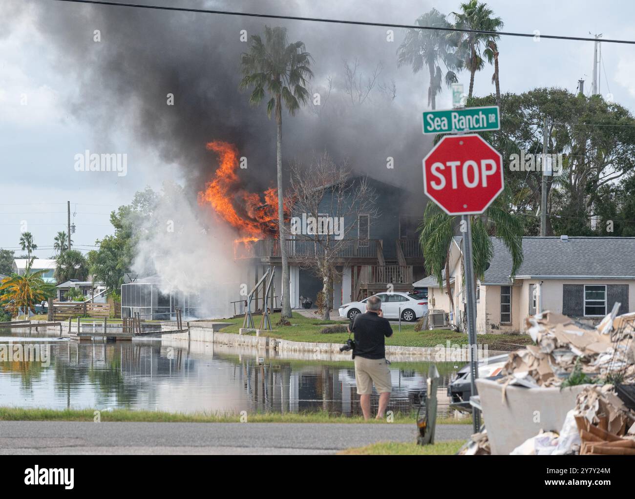 Hudson, FL, 1. Oktober 2024 -- wie um die Verletzung noch weiter zu belasten, fing ein Haus in der Sea Ranch Gegend von Hudson, FL in Brand, nachdem die meisten Häuser hier letzte Woche mehrere Meter Wasser vom Hurrikan Helene eingenommen haben. Foto von Liz Roll Stockfoto
