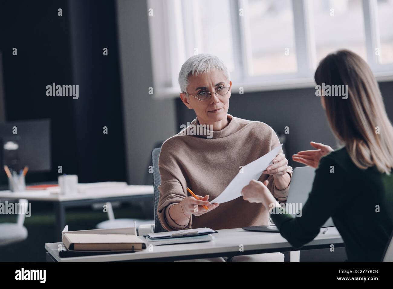 Selbstbewusste HR-Managerin, die am Schreibtisch sitzt, ein Interview mit dem Kandidaten führt Stockfoto