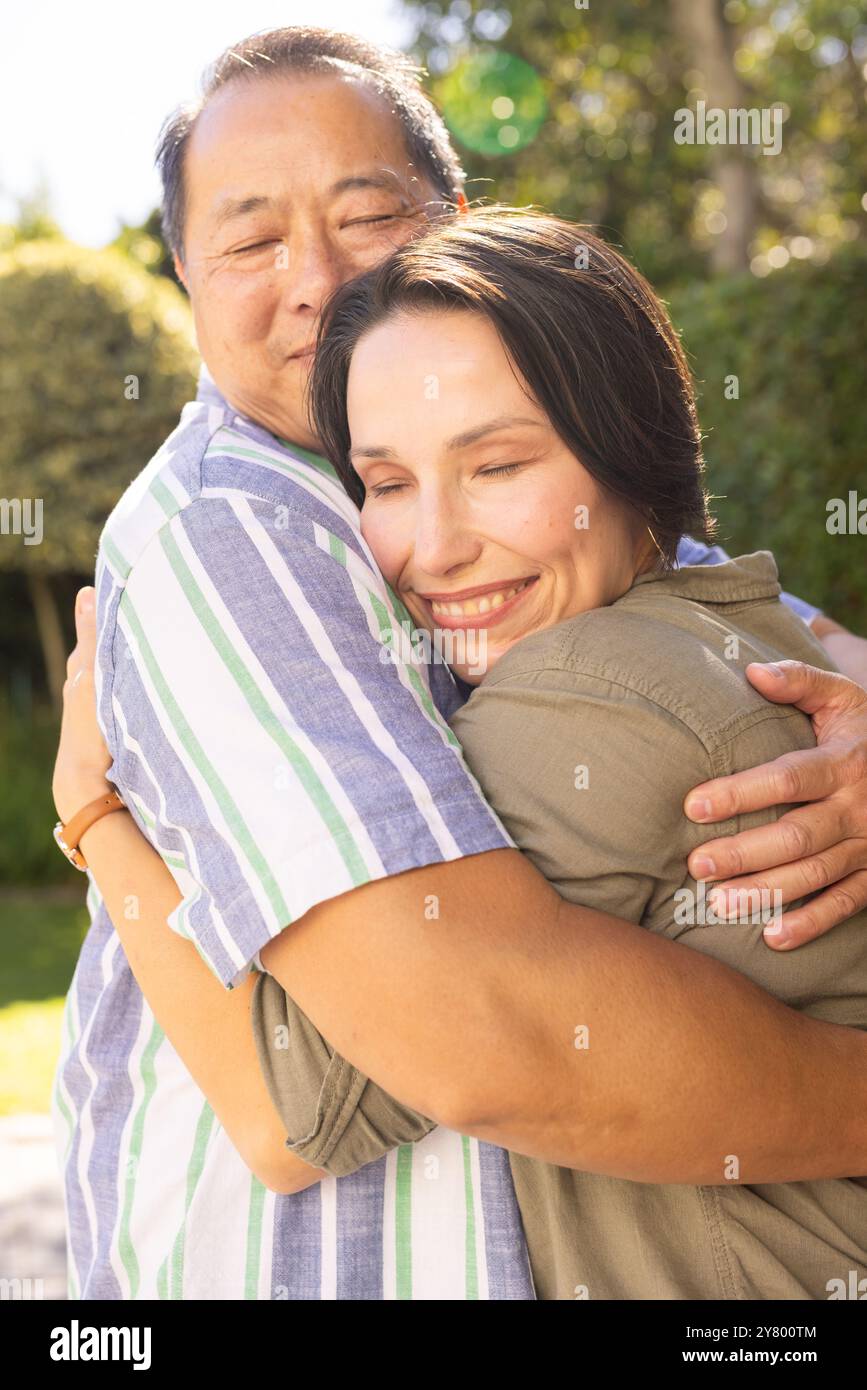 Mann im Freien umarmt, lächelnde Frau, die die gemeinsame Familienzeit genießt Stockfoto