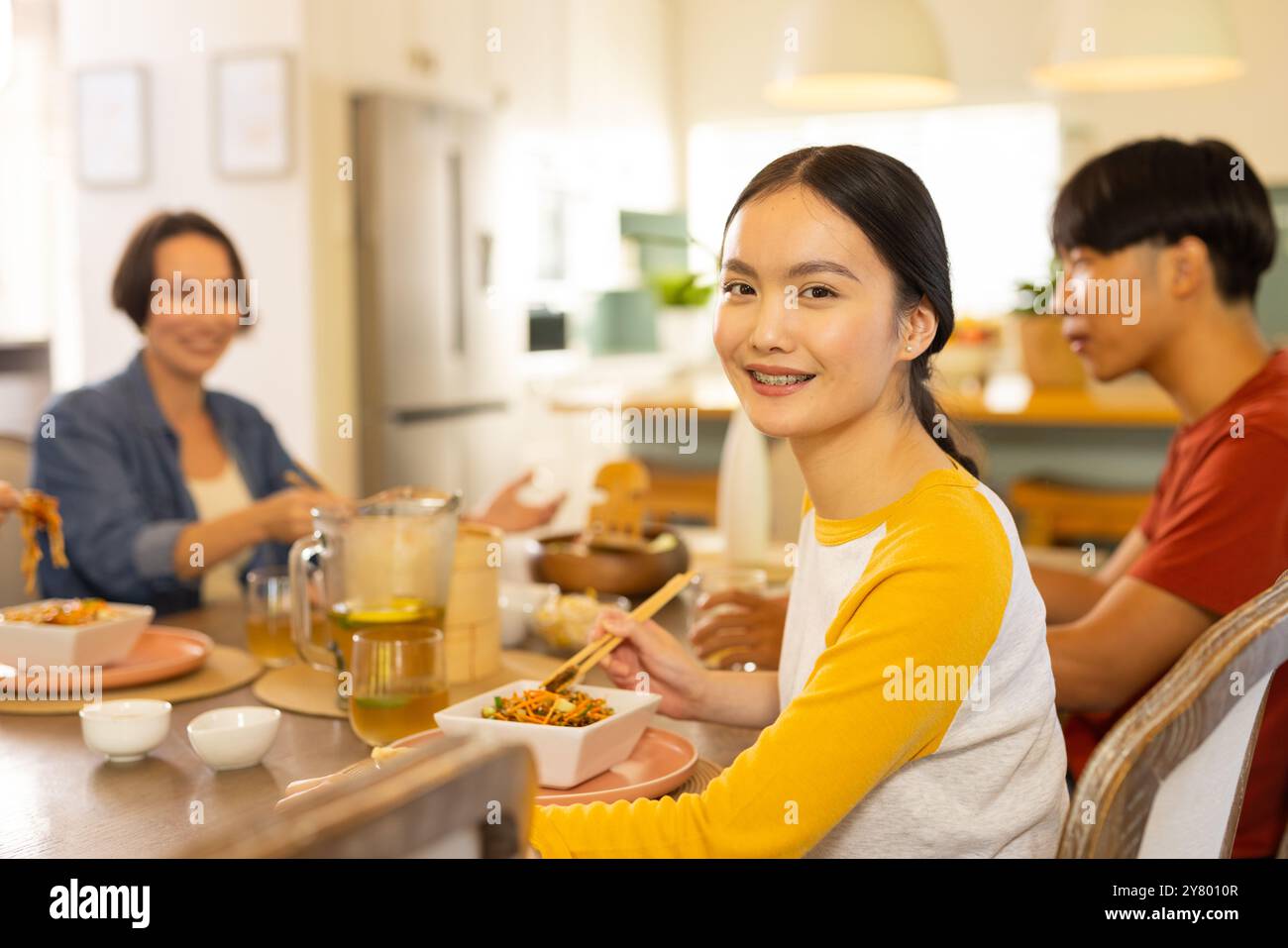 Zu Hause, zusammen essen, asiatische Familie essen essen und lächeln am Esstisch Stockfoto