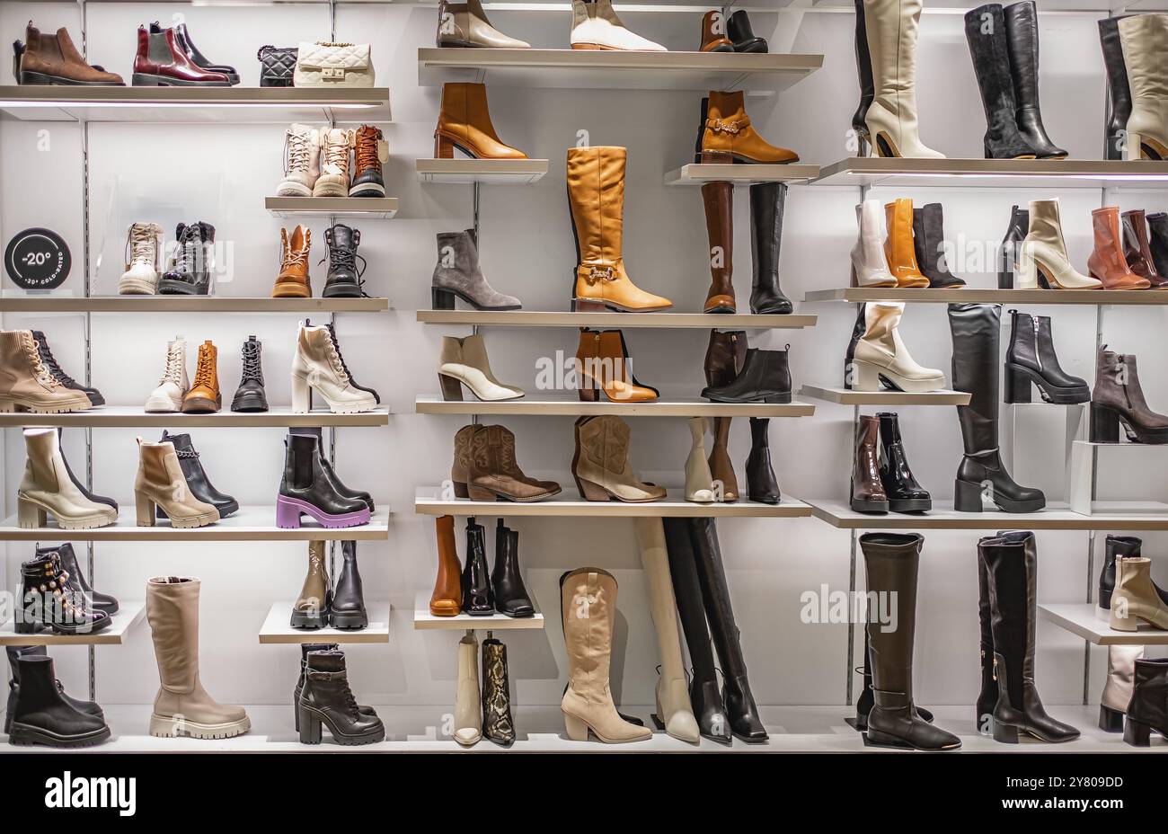 Damenstiefel zum Verkauf in einem Schuhgeschäft. Damenstiefel in den Regalen im Laden. Pavillon des Geschäfts mit modischen Damenschuhen. Leder Herbst W Stockfoto