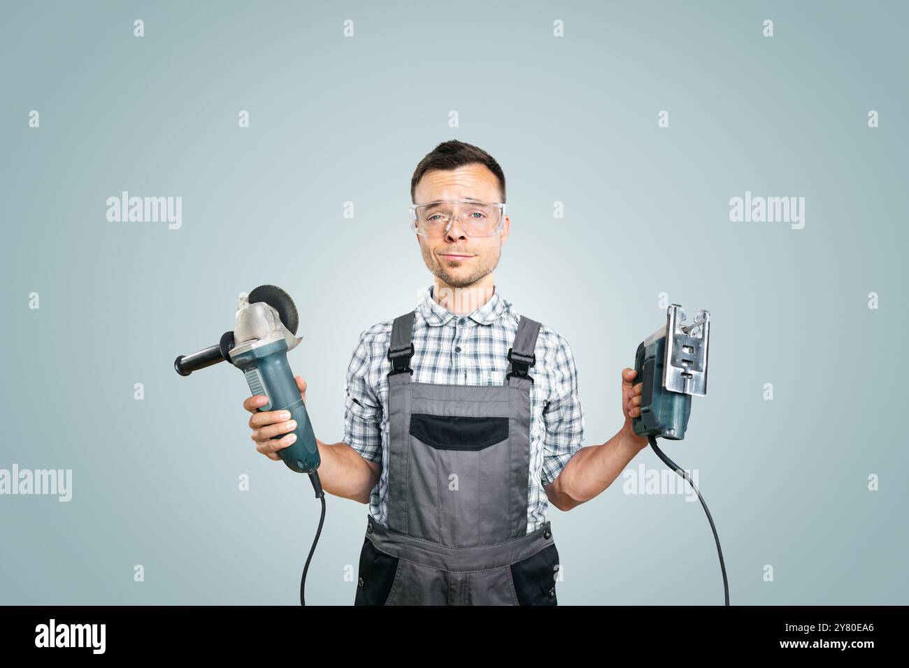 Porträt eines Arbeiters, der Elektrowerkzeuge in beiden Händen hält Stockfoto