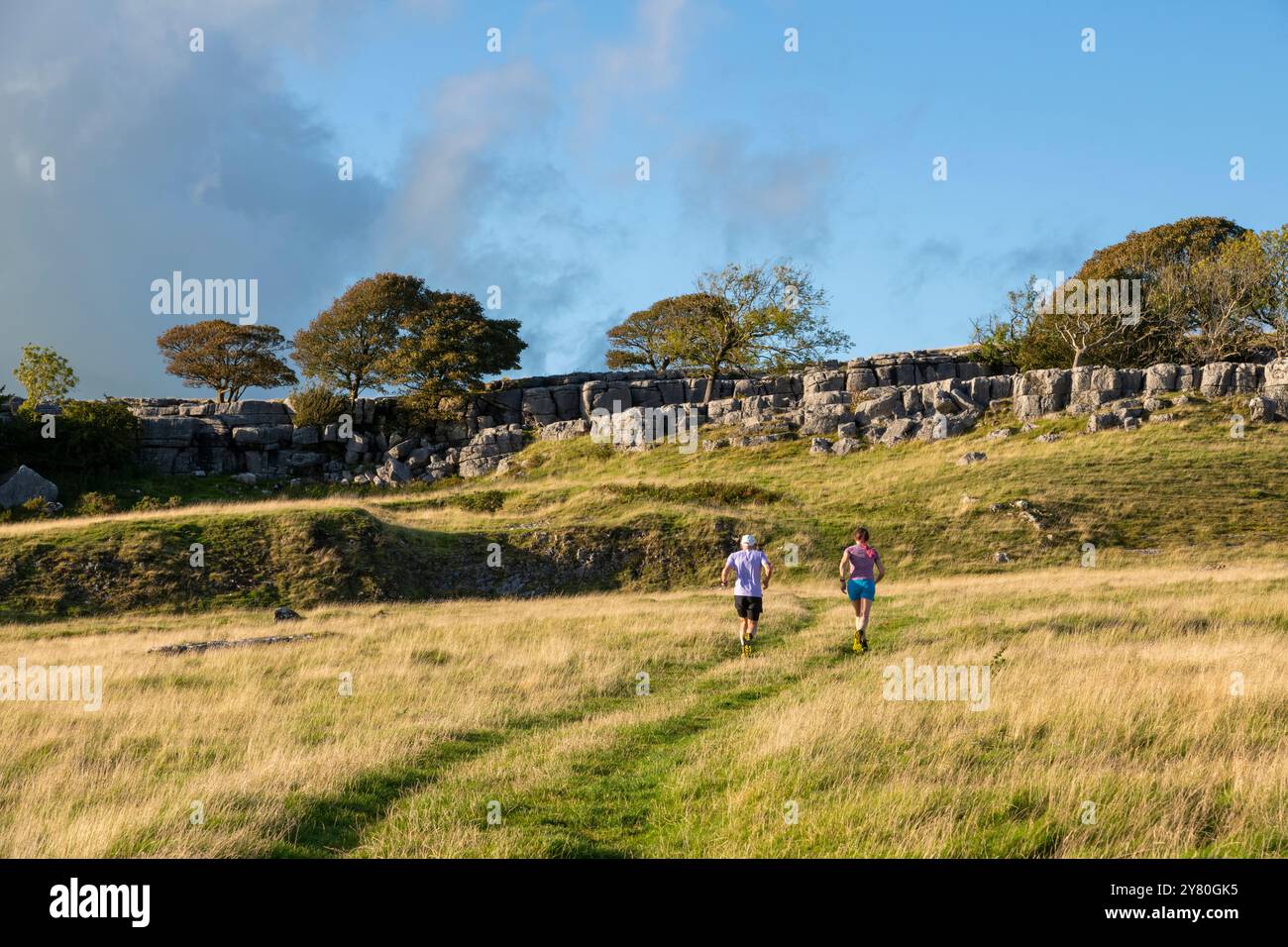 Zwei Läufer bei Newbiggin Crags, einer Kalksteinpflasterlandschaft in der Nähe von Burton in Lonsdale, Cumbria, England. Stockfoto