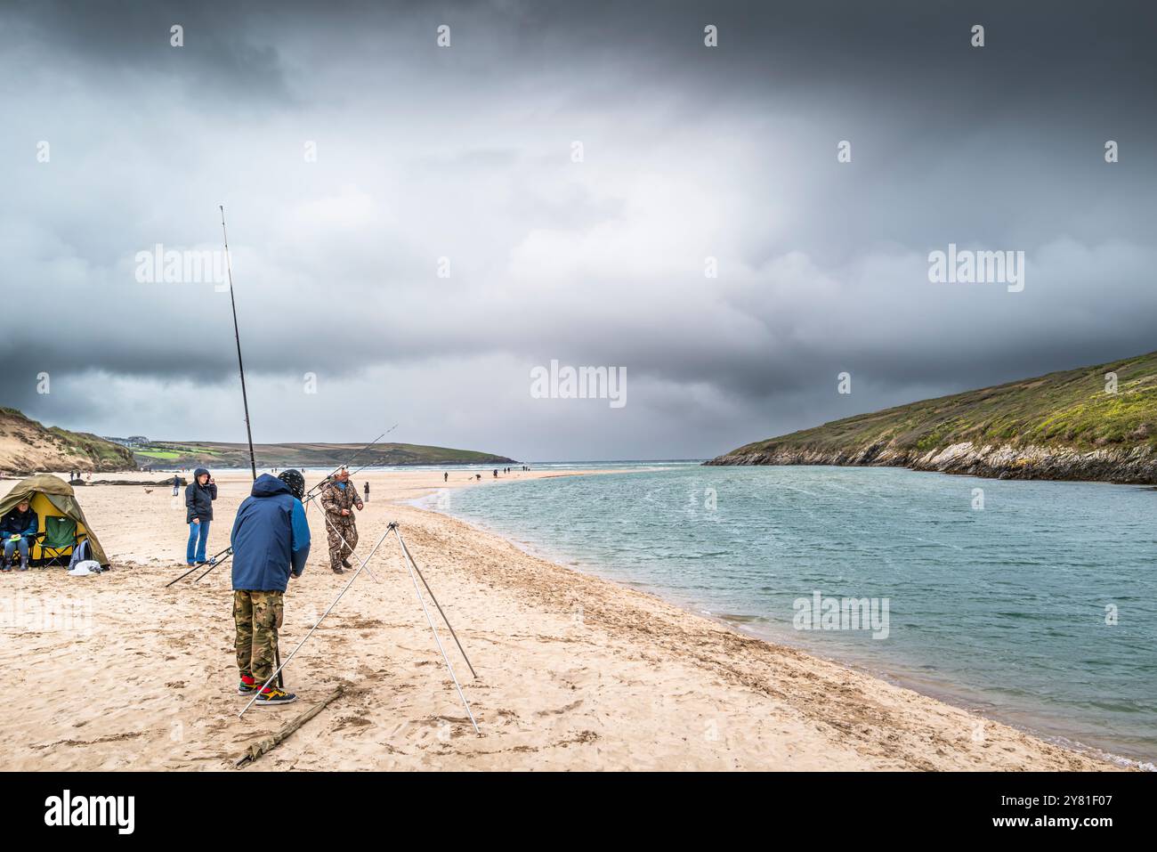 Angler fischen im Tidal Gannel River am Crantock Beach in Newquay in Cornwall, Großbritannien. Stockfoto