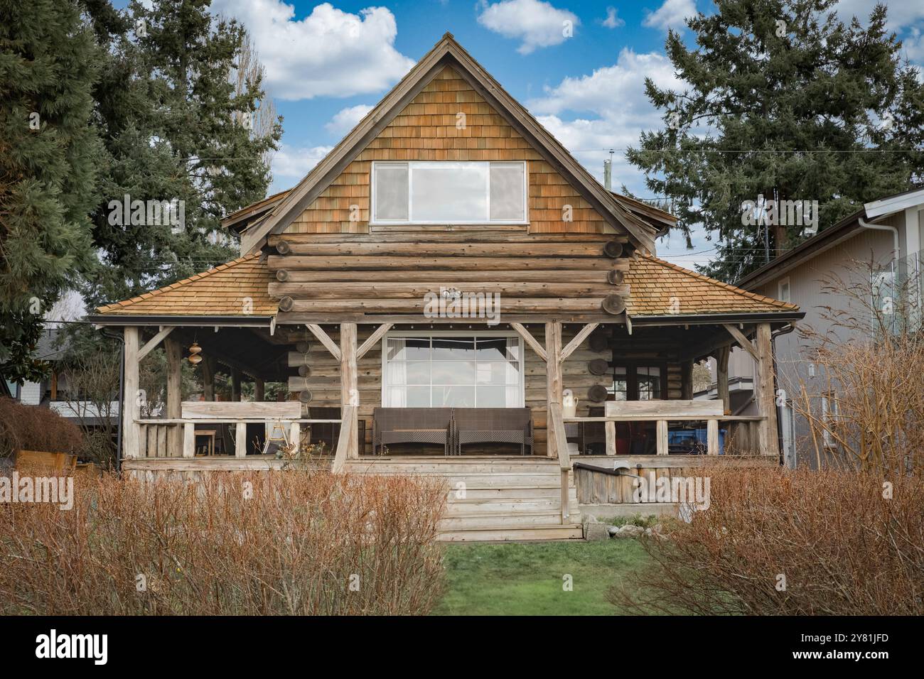 Landhaus in Nordamerika. Holzhaus im grünen Wald. Holzhaus oder Ferienhaus mit Bäumen herum. Heim im Landhausstil. Außenansicht des Landhauses Stockfoto