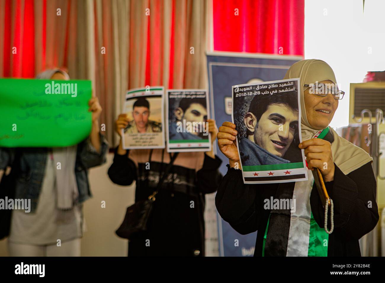 Gaziantep, Turkiye. 28. September 2023. Einige Mitglieder syrischer Gemeindeorganisationen treffen sich in der Bulbulzadeh Hall in der Innenstadt von Gaziantep, um Solidarität mit den anhaltenden regierungsfeindlichen Protesten in der syrischen Südweststadt Suweida zu zeigen. Während der Veranstaltung in der südtürkischen Stadt Gaziantep hissen einige Teilnehmer die syrische Oppositionsflagge sowie Banner gegen die nationale Koalition der syrischen Revolution und der Oppositionskräfte. Der Organisator der Veranstaltung, Ensaf Naser, argumentierte, dass die syrische Nationalkoalition die Syrer nicht repräsentiere. Während ihrer Rede kritisierte Naser die Stockfoto