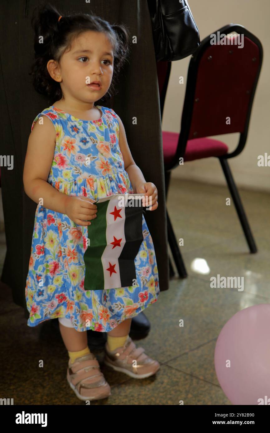 Gaziantep, Turkiye. 28. September 2023. Einige Mitglieder syrischer Gemeindeorganisationen treffen sich in der Bulbulzadeh Hall in der Innenstadt von Gaziantep, um Solidarität mit den anhaltenden regierungsfeindlichen Protesten in der syrischen Südweststadt Suweida zu zeigen. Während der Veranstaltung in der südtürkischen Stadt Gaziantep hissen einige Teilnehmer die syrische Oppositionsflagge sowie Banner gegen die nationale Koalition der syrischen Revolution und der Oppositionskräfte. Der Organisator der Veranstaltung, Ensaf Naser, argumentierte, dass die syrische Nationalkoalition die Syrer nicht repräsentiere. Während ihrer Rede kritisierte Naser die Stockfoto