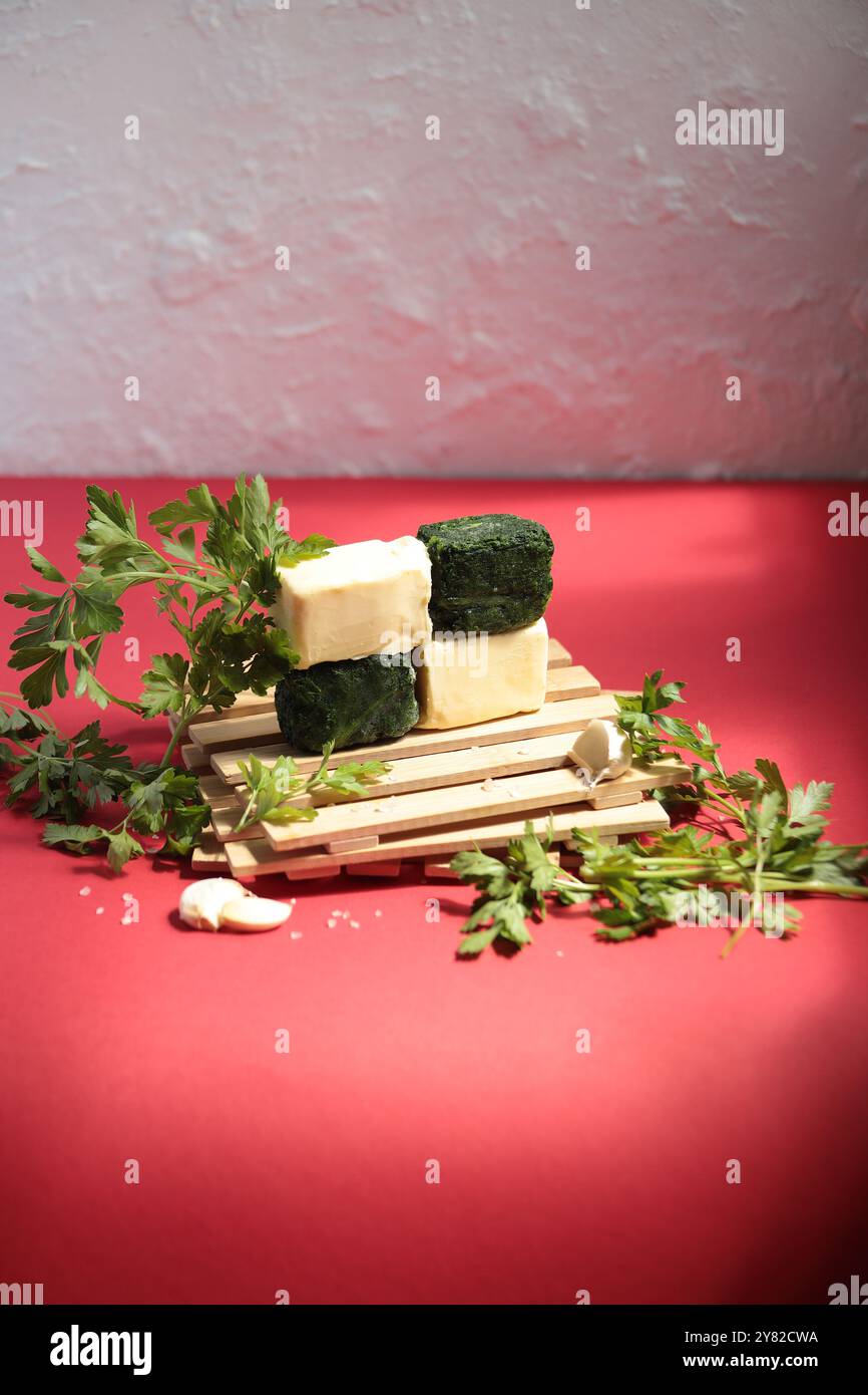 Frische Zutaten für Spinatbutter-Sandwiches auf einem leuchtend roten Hintergrund, die natürliche Texturen und Farben in einer lebendigen, appetitlichen Präsentation hervorheben Stockfoto