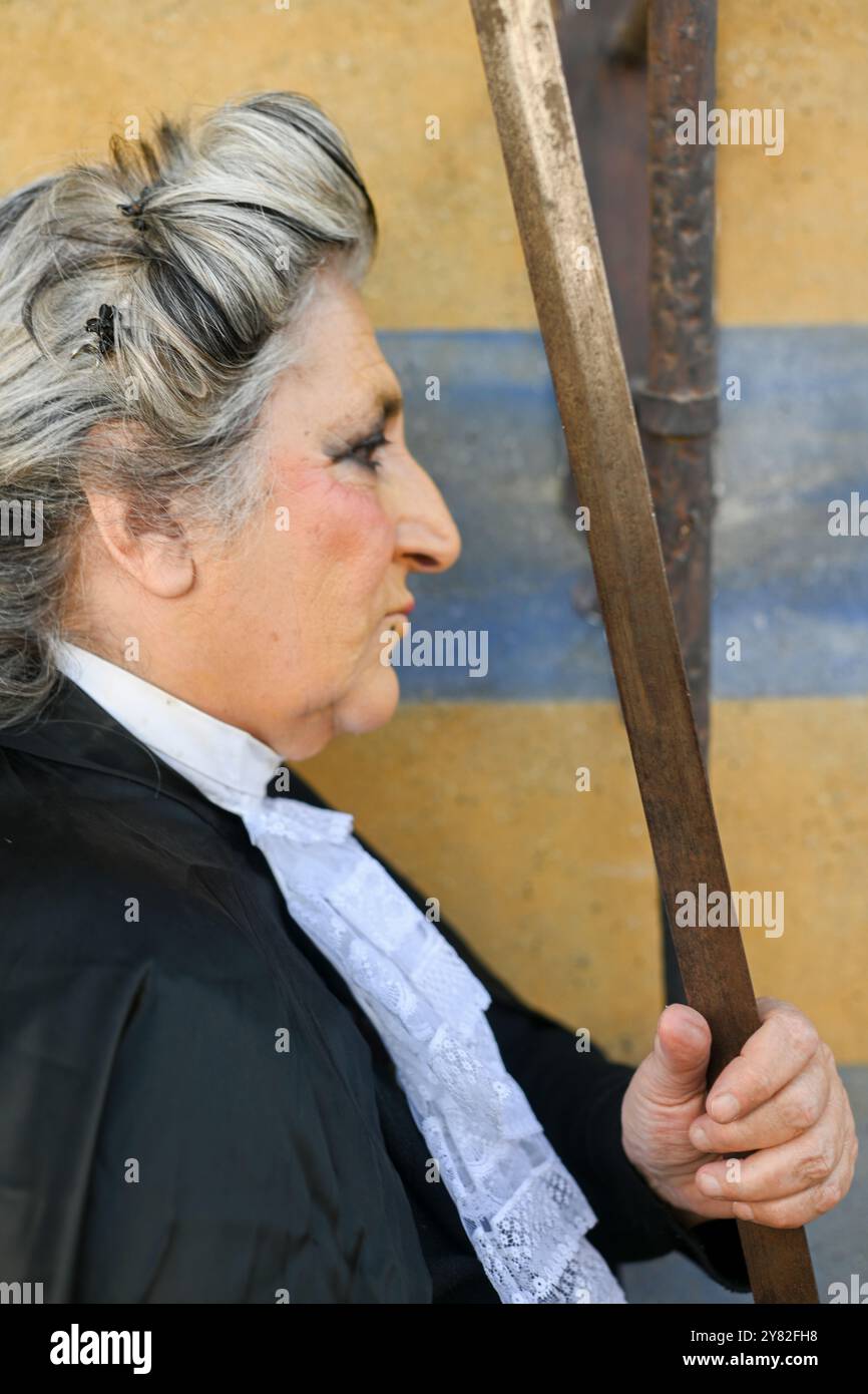 Die als Richter gekleidete reife Frau strahlt Autorität und Macht aus, die ein Schwert hält und Gerechtigkeit und Korruption symbolisiert und ethische Dilemmata im Bein widerspiegelt Stockfoto