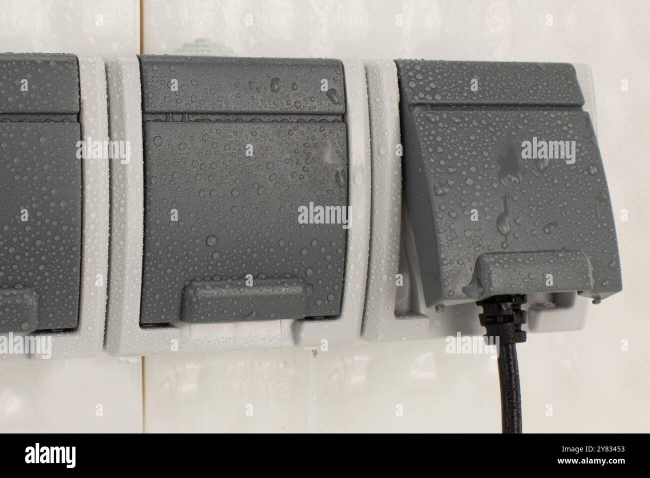 Steckdose für den Außenbereich mit Wassertropfen bedeckt Stockfoto