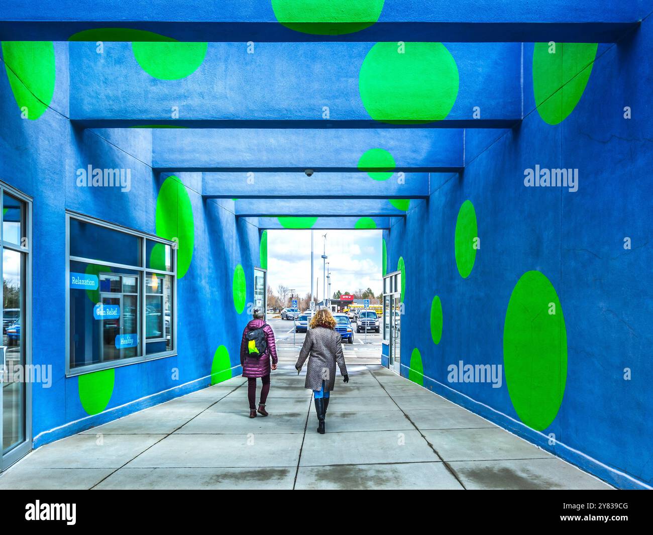 Einkaufspassage mit blau lackierten Wänden und Balken mit großen grünen Flecken - Lakewood, Denver, Colorado, USA. Stockfoto