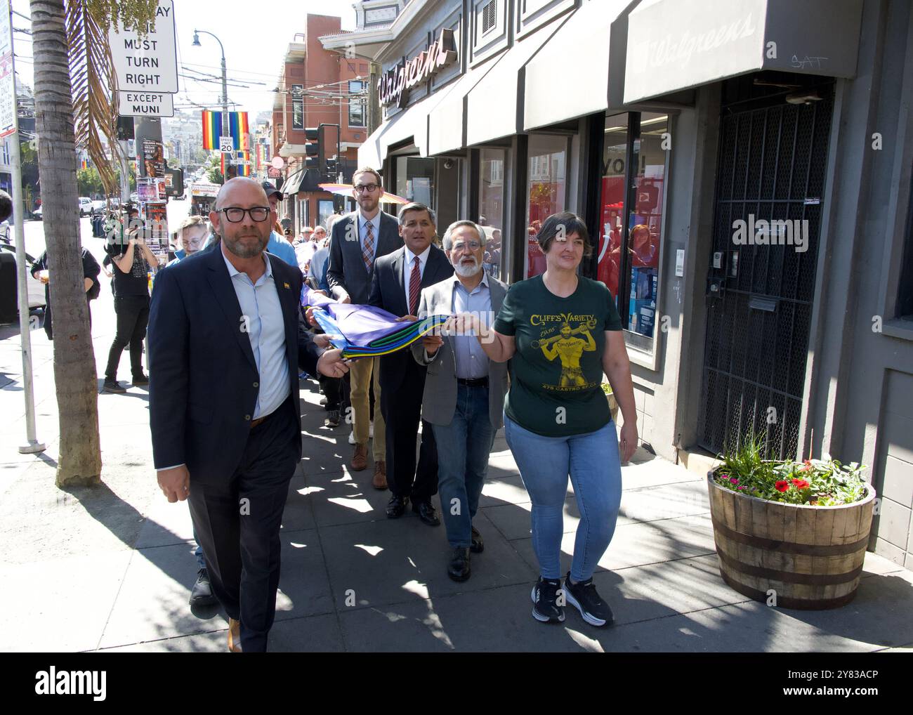 San Francisco, KALIFORNIEN – 13. September 2024: Gewählte und städtische Beamte mit großer Regenbogenfahne für schwule Rechte, die am Bahnhof hängen soll Stockfoto