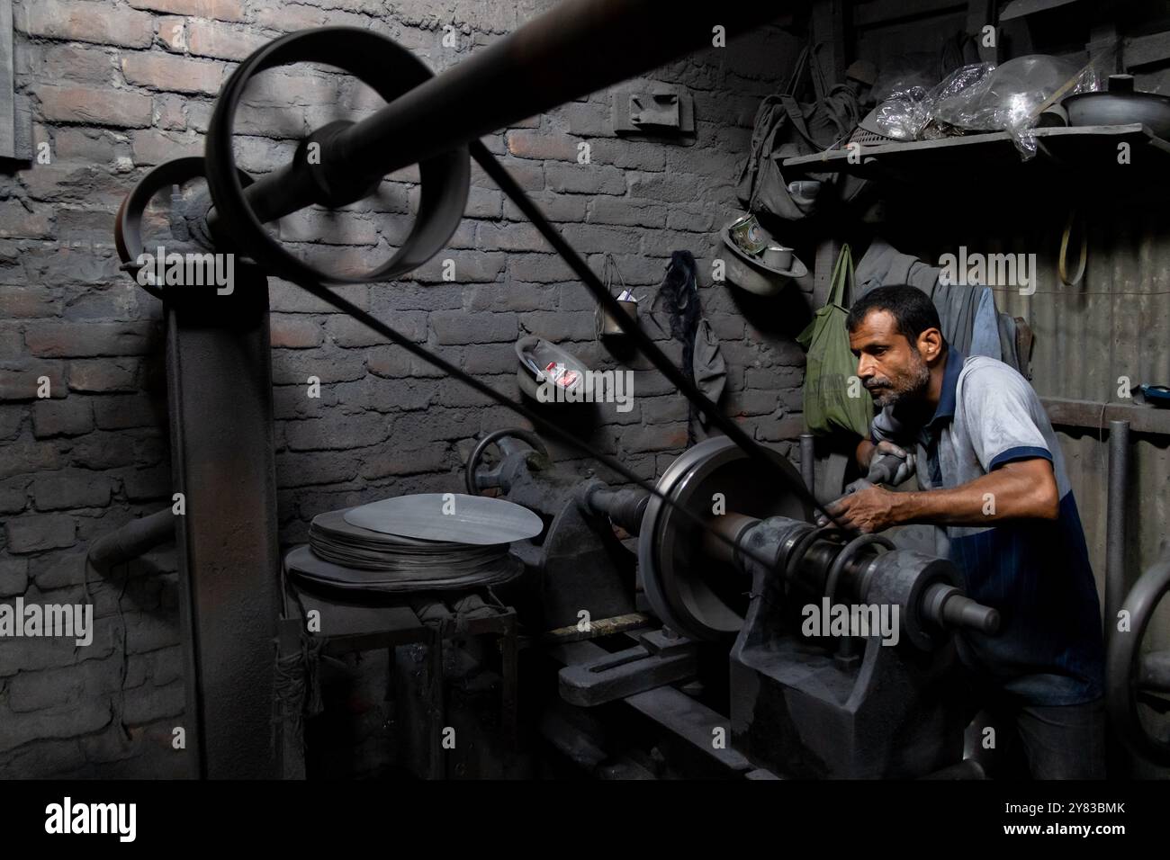 Dhaka, Dhaka, Bangladesch. Oktober 2024. In Kamrangirchar in Dhaka arbeiten Aluminiumfabriken unter gefährlichen Bedingungen. Arbeiter ohne Schutzausrüstung sind mit schädlichem Aluminiumstaub beschichtet, wenn sie schwere Maschinen in einer engen, schwach beleuchteten Umgebung handhaben. Wenn sie minimalem Licht von oben ausgesetzt sind, stehen sie neben gesundheitlichen Problemen vor schweren Sehstörungen. (Kreditbild: © Joy Saha/ZUMA Press Wire) NUR REDAKTIONELLE VERWENDUNG! Nicht für kommerzielle ZWECKE! Stockfoto