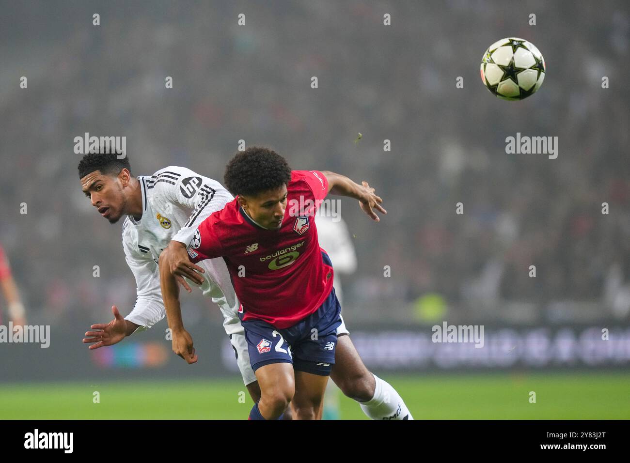 Lille's Tiago Santos, center, and Real Madrid's Jude Bellingham vie for the ball during the Champions League opening phase soccer match between Lille and Real Madrid at the Stade Pierre Mauroy in Villeneuve-d'Ascq, outside Lille, France, Wednesday, Oct. 2, 2024. (AP Photo/Thibault Camus) Stockfoto