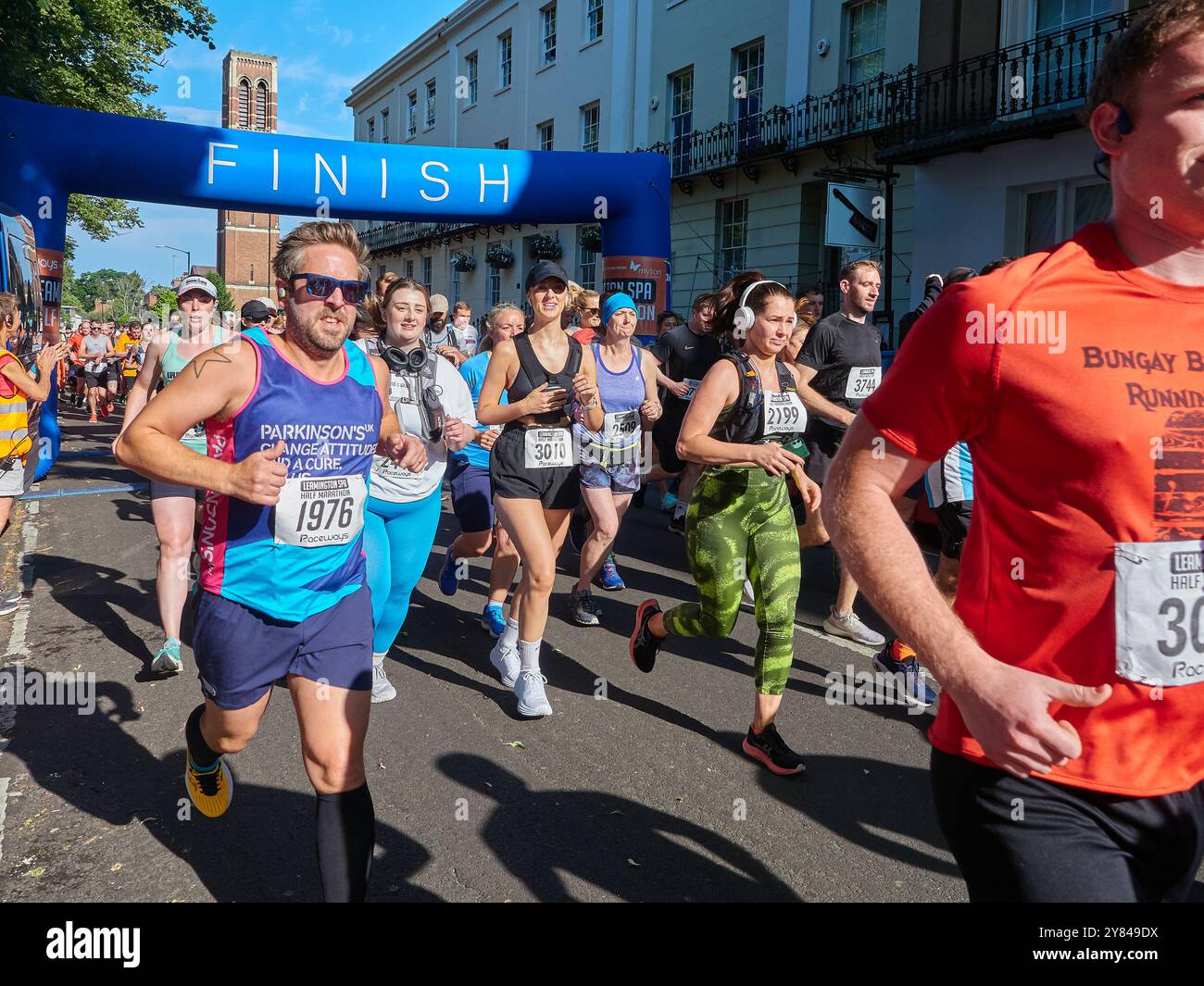 Läuferin für Parkinson-Krankheit-Wohltätigkeitsorganisation unter anderem zu Beginn eines Halbmarathons. Stockfoto