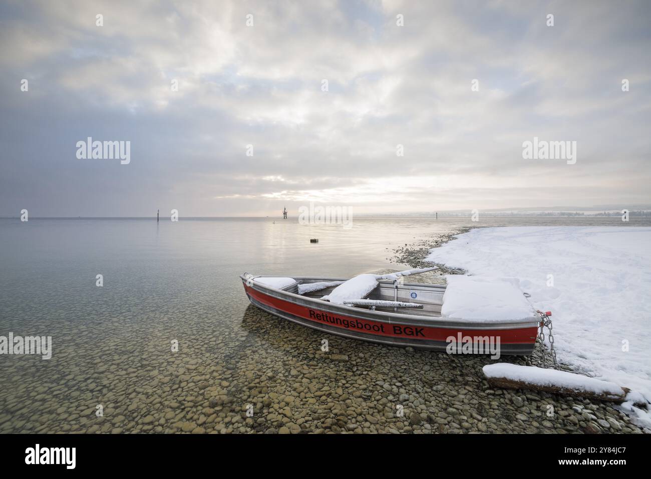 Ein Rettungsboot liegt am schneebedeckten Seeufer unter bewölktem Himmel, Strandbad Hoernle, Konstanz, Bodensee, Baden-Württemberg, Deutschland, Europa Stockfoto