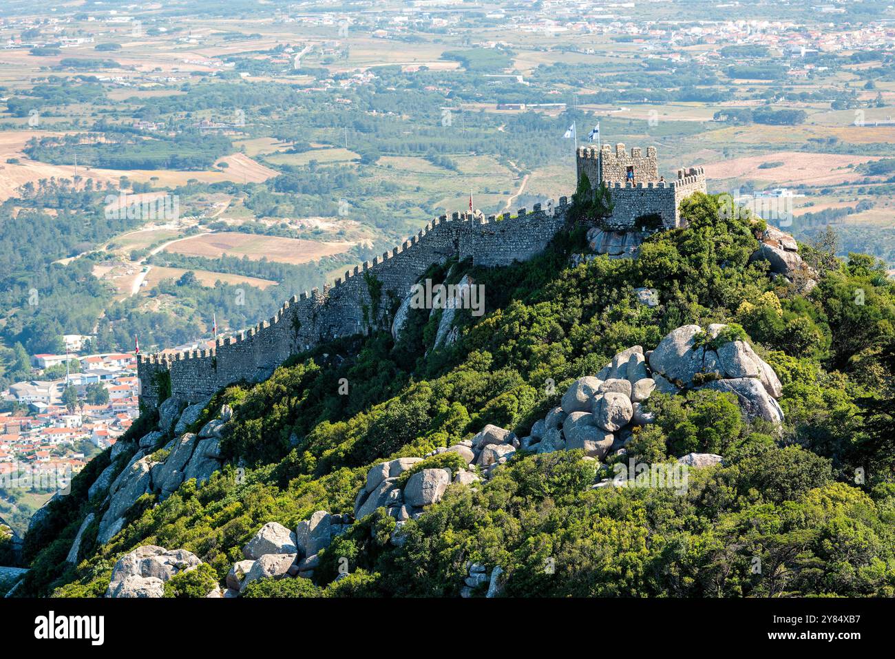 SINTRA, Portugal – die maurische Burg (Castelo dos Mouros) steht auf einem Hügel oberhalb der Stadt Sintra. Diese mittelalterliche Festung mit ihren Steinmauern, die sich entlang des Berges schlängeln, bietet eine dramatische Silhouette am Himmel und bietet einen beeindruckenden Blick auf die umliegende Landschaft. Stockfoto