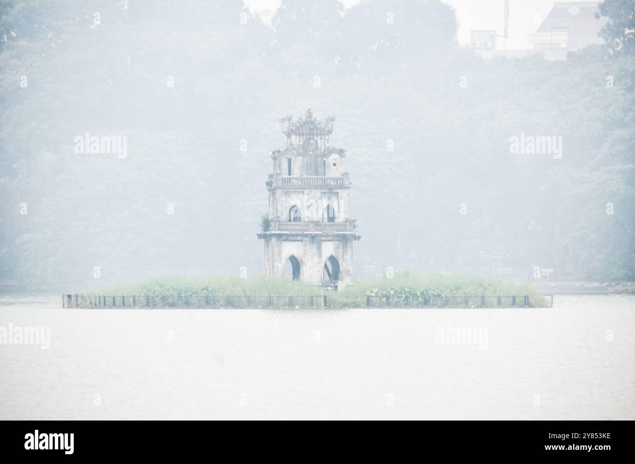 Turtle Tower Thap Rua Hoan Kiem Lake Hanoi Vietnam // HANOI, Vietnam — der historische Turtle Tower (Thap Rua) ragt durch den Morgennebel auf dem Hoan Kiem Lake hervor. Der Turm aus dem 19. Jahrhundert, der auf einer kleinen Insel im Zentrum des Sees errichtet wurde, erinnert an die legendäre goldene Schildkröte der vietnamesischen Folklore. Dieses ikonische Gebäude ist eines der bekanntesten Wahrzeichen Hanois im historischen Viertel der Stadt. Stockfoto