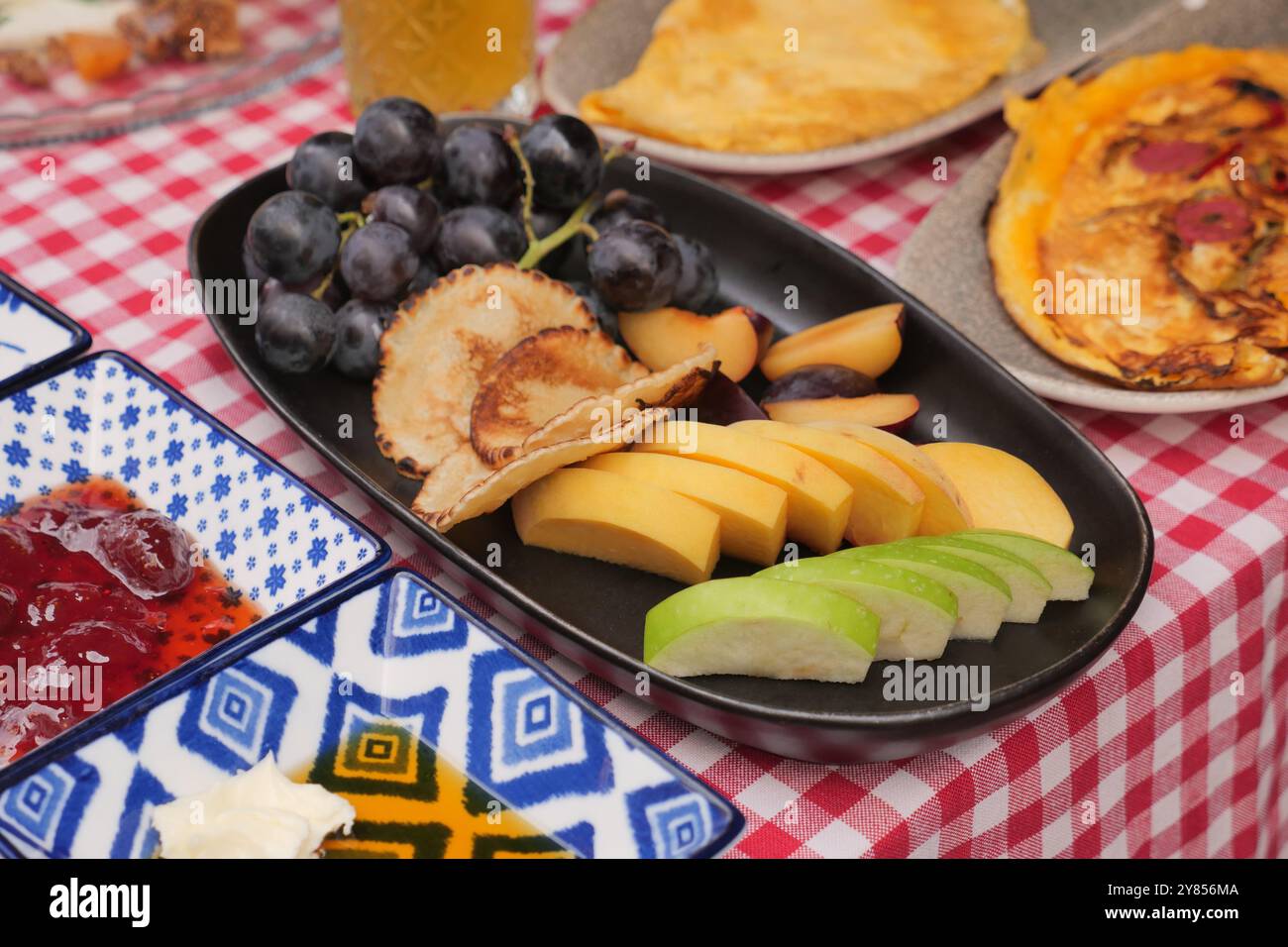 Ein farbenfroher und einladender Obstteller, der wunderschön auf einem Picknicktisch für alle präsentiert wird Stockfoto