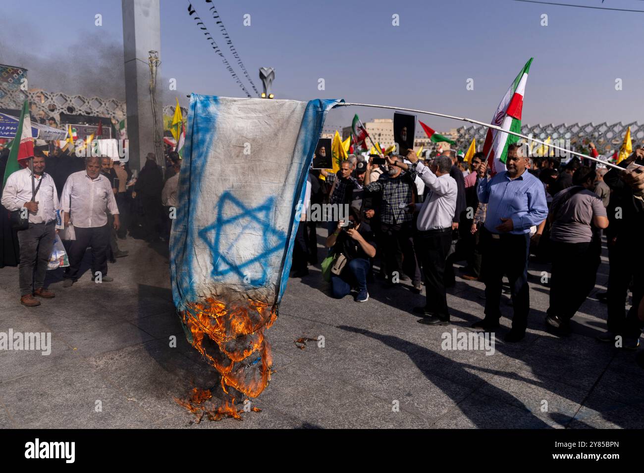 Teheran, Iran. Oktober 2024. Demonstranten verbrennen bei einer Demonstration zum Gedenken an den getöteten Hisbollah-Führer Hassan Nasrallah in Teheran Repräsentationen der israelischen Flagge. (Kreditbild: © Sobhan Farajvan/Pacific Press via ZUMA Press Wire) NUR REDAKTIONELLE VERWENDUNG! Nicht für kommerzielle ZWECKE! Stockfoto