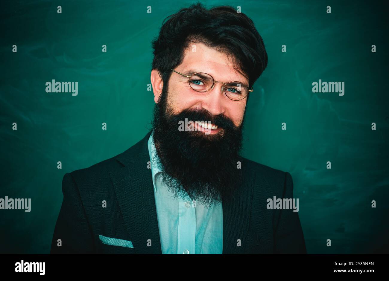 Lehrer stellen Herausforderungen und inspirieren. Bärtiger Professor am Schulunterricht an Schreibtischen im Klassenzimmer. Junger bärtiger Lehrer in der Nähe einer Tafel im Schulunterricht. Stockfoto