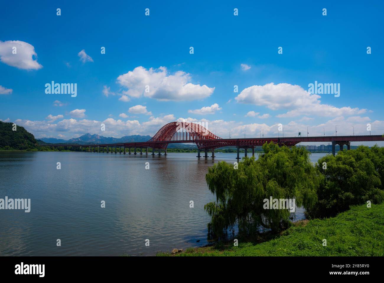 Malerischer Blick auf die Banghwa Bridge über den Han River in Seoul mit ihrem leuchtend roten Bogen vor einem klaren Himmel. Stockfoto