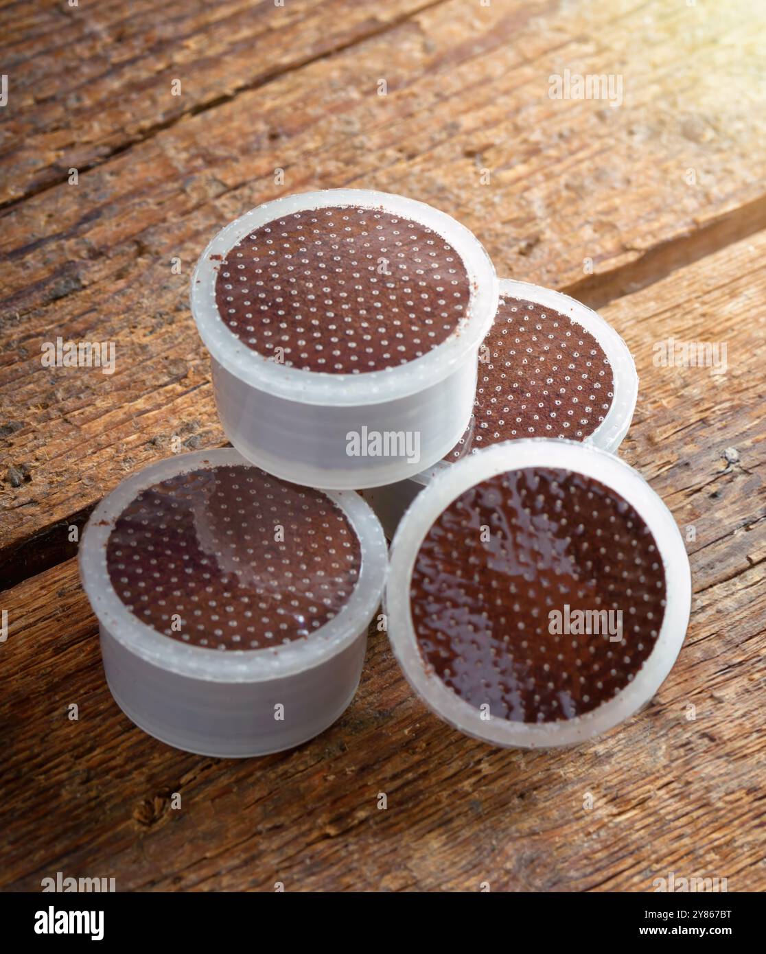 Genießen Sie eine frische Tasse Kaffee mit diesen Kaffeepads zum Einmalgebrauch auf einer rustikalen Holzoberfläche Stockfoto