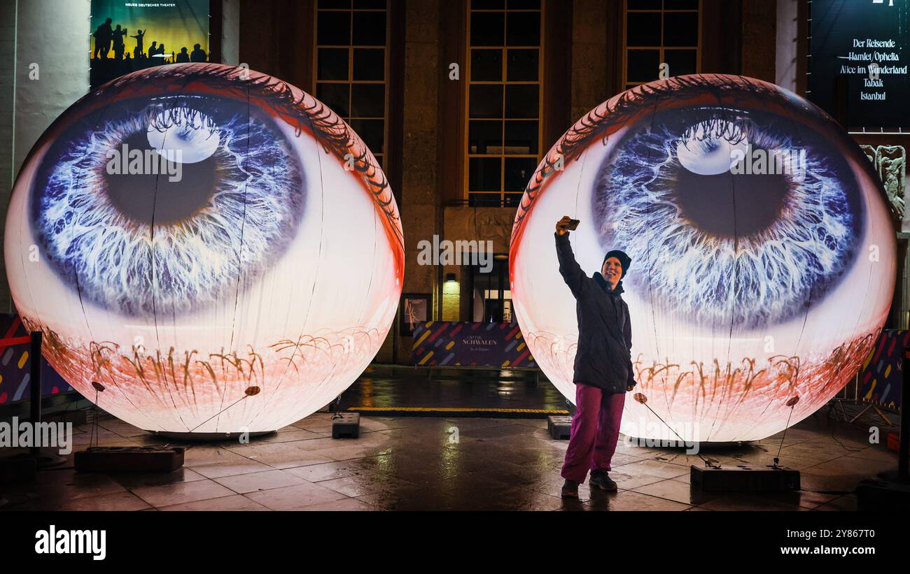 Essen, NRW, Deutschland. Oktober 2024. Besucher interagieren mit der Installation „Oculus“ der Künstler H:E:M (Italien) außerhalb des Grillo-Theaters. Zwei riesige Kugeln leuchten in Form von zwei Augen, die in den Himmel blicken. Eröffnungsabend des jährlichen Essen Light Festivals mit 16 großformatigen Lichtinstallationen in der ganzen Stadt. Das Festival ist frei zu sehen und findet jeden Abend von Sonnenuntergang bis 23 Uhr vom 2. Bis 13. Oktober 2024 statt. Quelle: Imageplotter/Alamy Live News Stockfoto