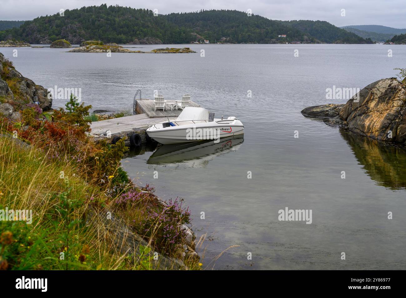 Ein Schnellboot liegt an einer privaten Anlegestelle auf einer Insel im Kragero-Archipel im Telemark County, Norwegen. Stockfoto