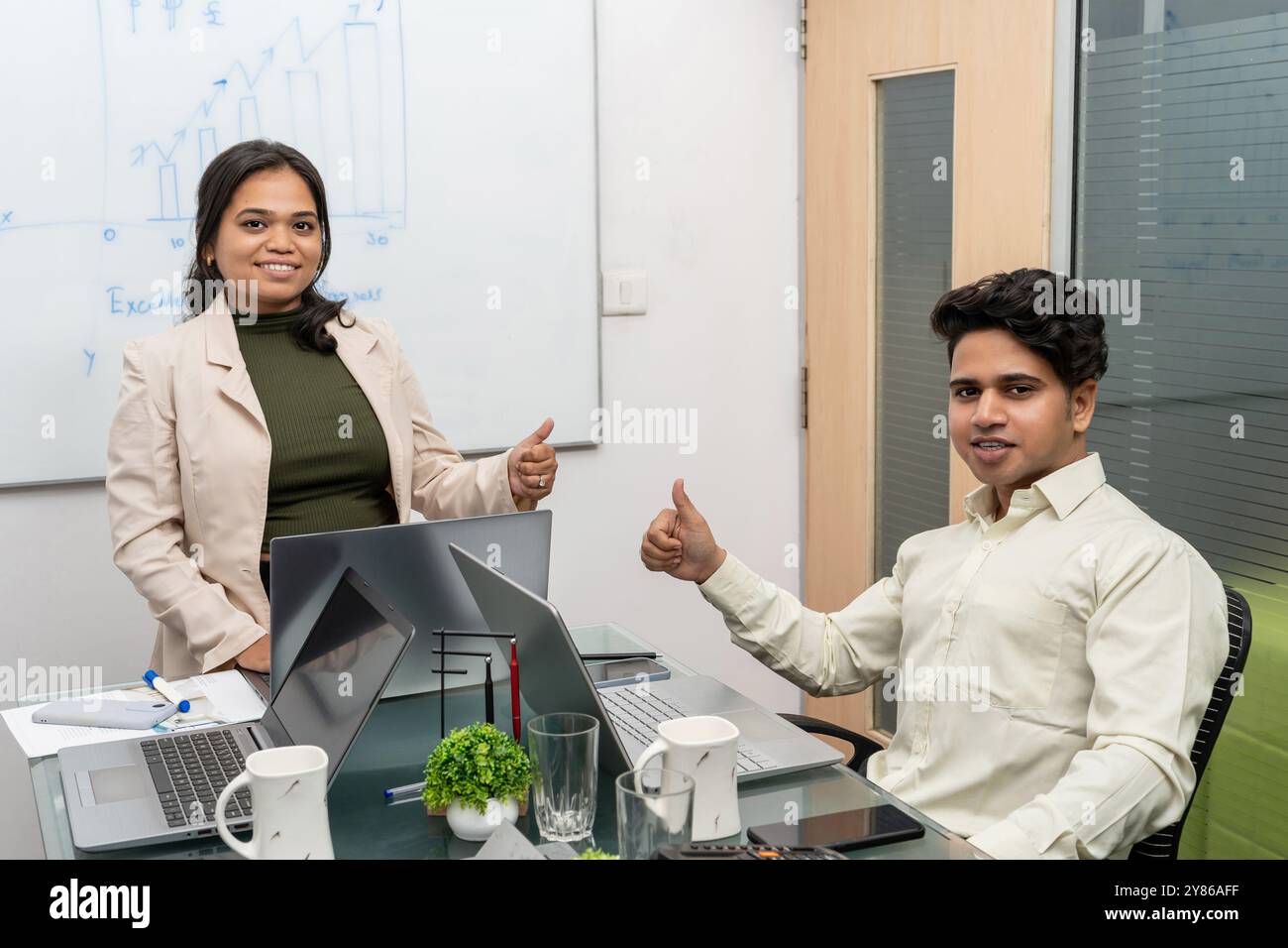 2 Geschäftsleute lächelnde, multirassische Kollegen, die im Büro ausgeben, Daumen hoch empfehlen guten Service, zufriedene Geschäftsleute empfehlen es Stockfoto