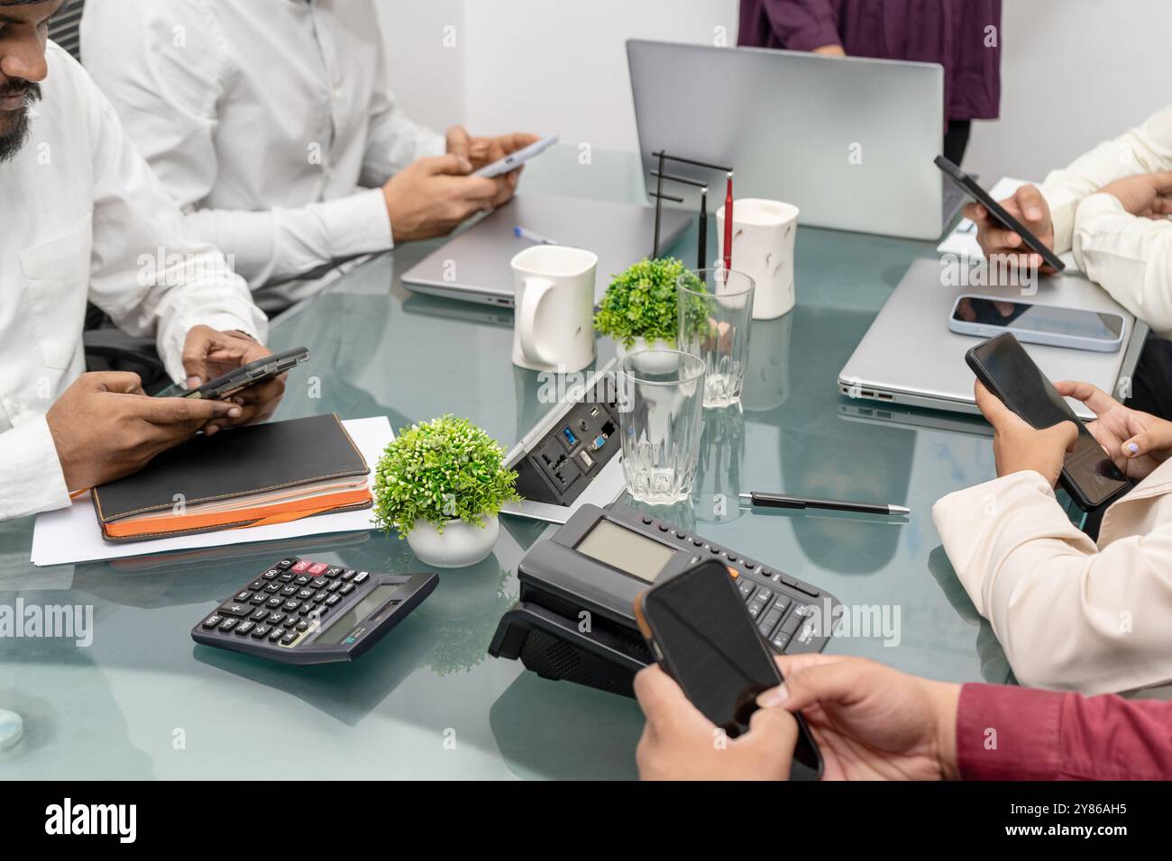 Unprofessionelles Verhalten im Besprechungsraum: Gruppe von Kandidaten wird von Mobiltelefonen abgelenkt, soziale Interaktion und berufliche Etiquette Gen z. ignoriert. Stockfoto