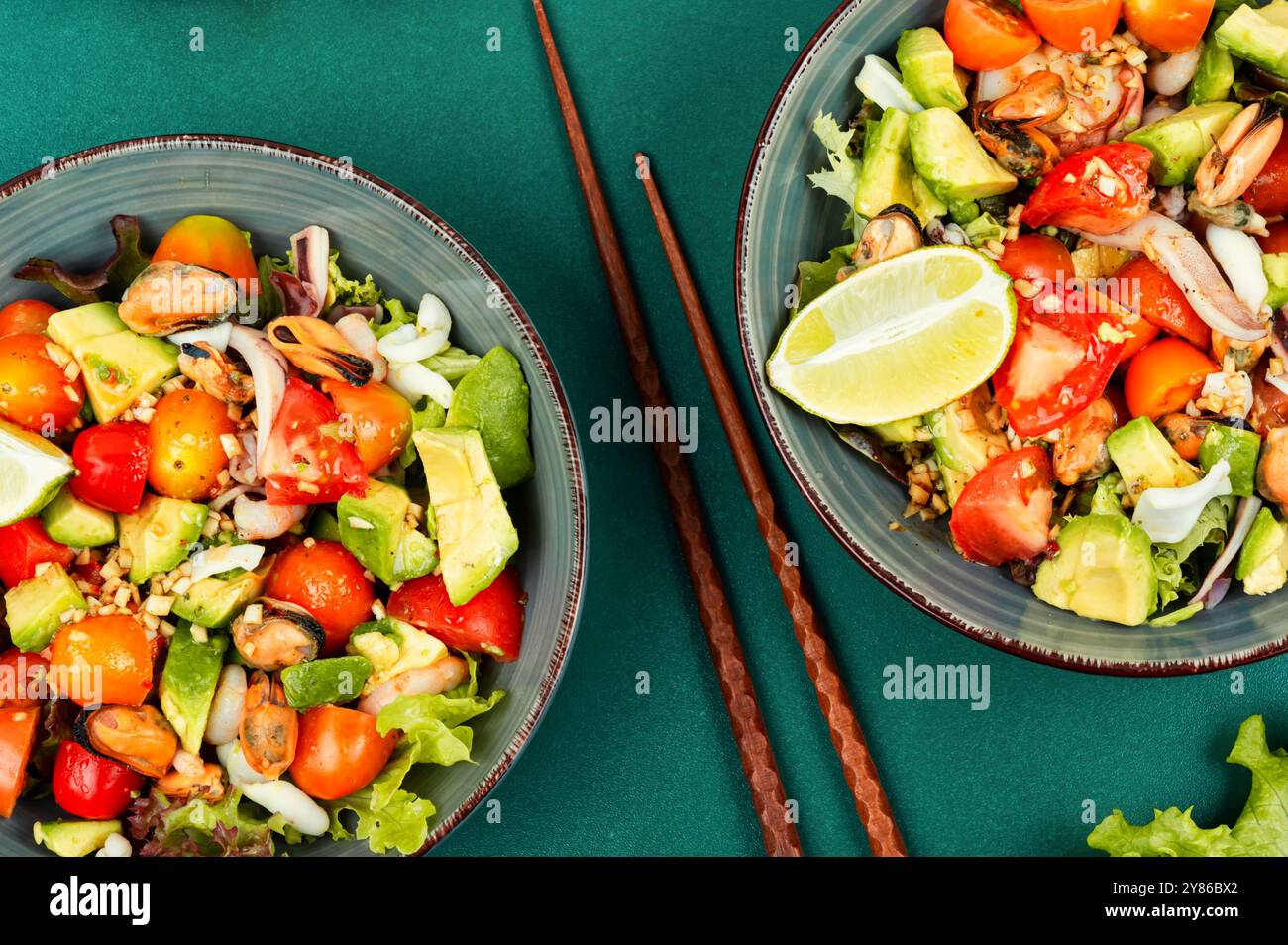 Salat mit Meeresfrüchten mit Garnelen, Tintenfischen, Muscheln, Tomaten, Avocado und gemischtem Gemüse in einer Schüssel. Gesunde Ernährung. Stockfoto