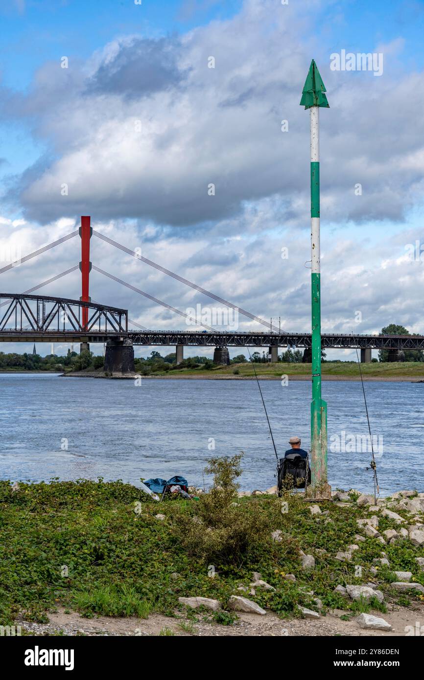 Die Beeckerwerth Rheinbrücke der Autobahn A42, davor die Haus-Knipp Eisenbahnbrücke, Angler am Rhein bei Duisburg, NRW Stockfoto