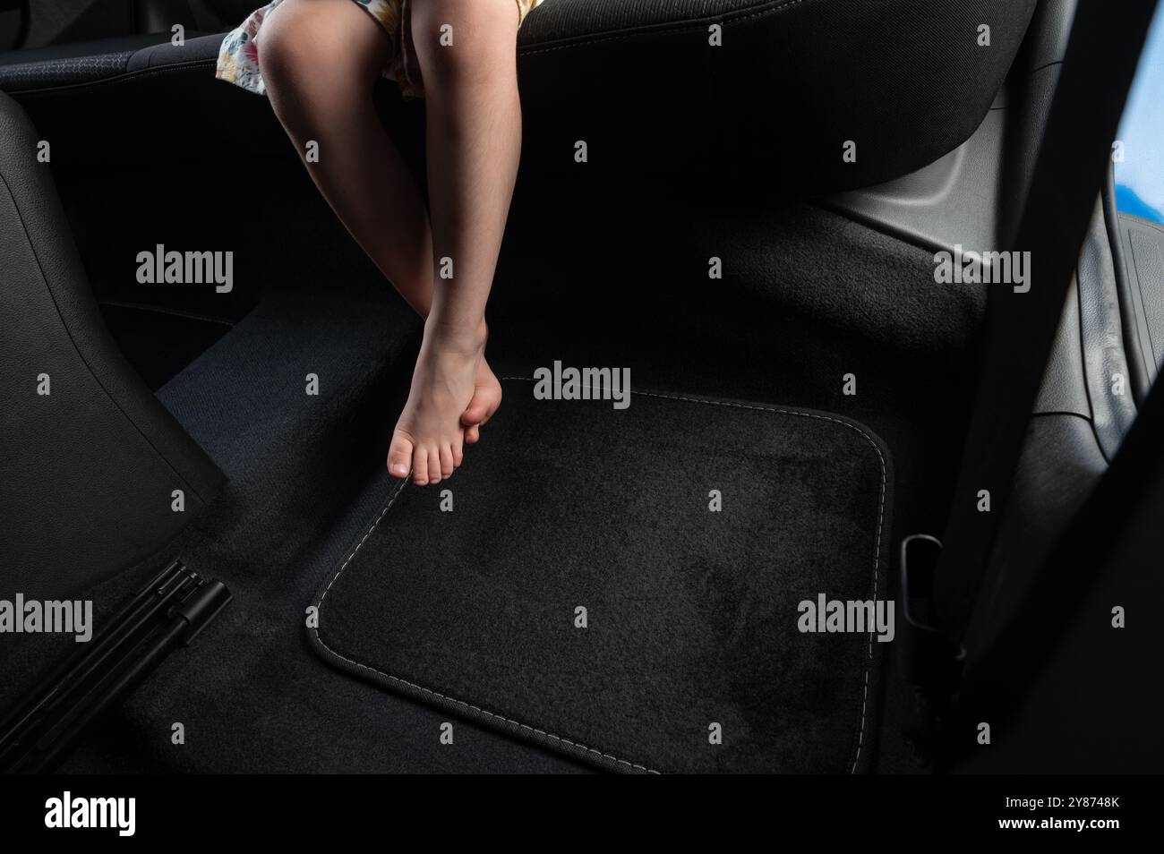 Kind barfuß in schwarzem Autoteppich Hintergrund Nahansicht Stockfoto