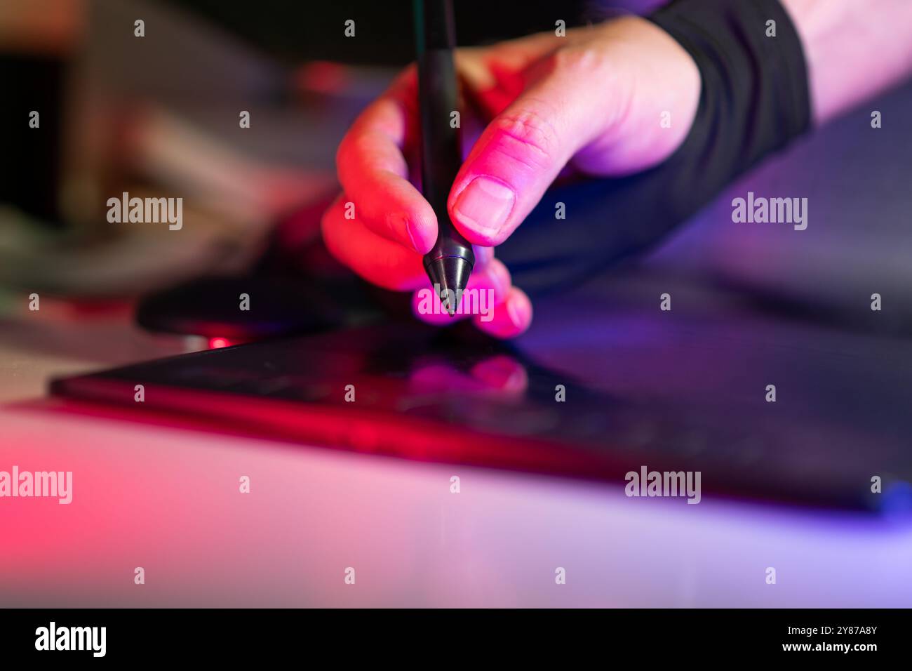 Grafikdesigner Digital Tablet Stylus Heimstudio Neonlicht innen Stockfoto