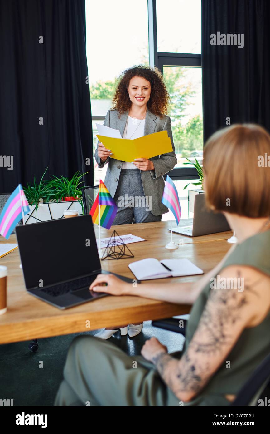 Kollegen diskutieren integrative Strategien, während sie in einem lebendigen Arbeitsbereich Stolz zeigen. Stockfoto