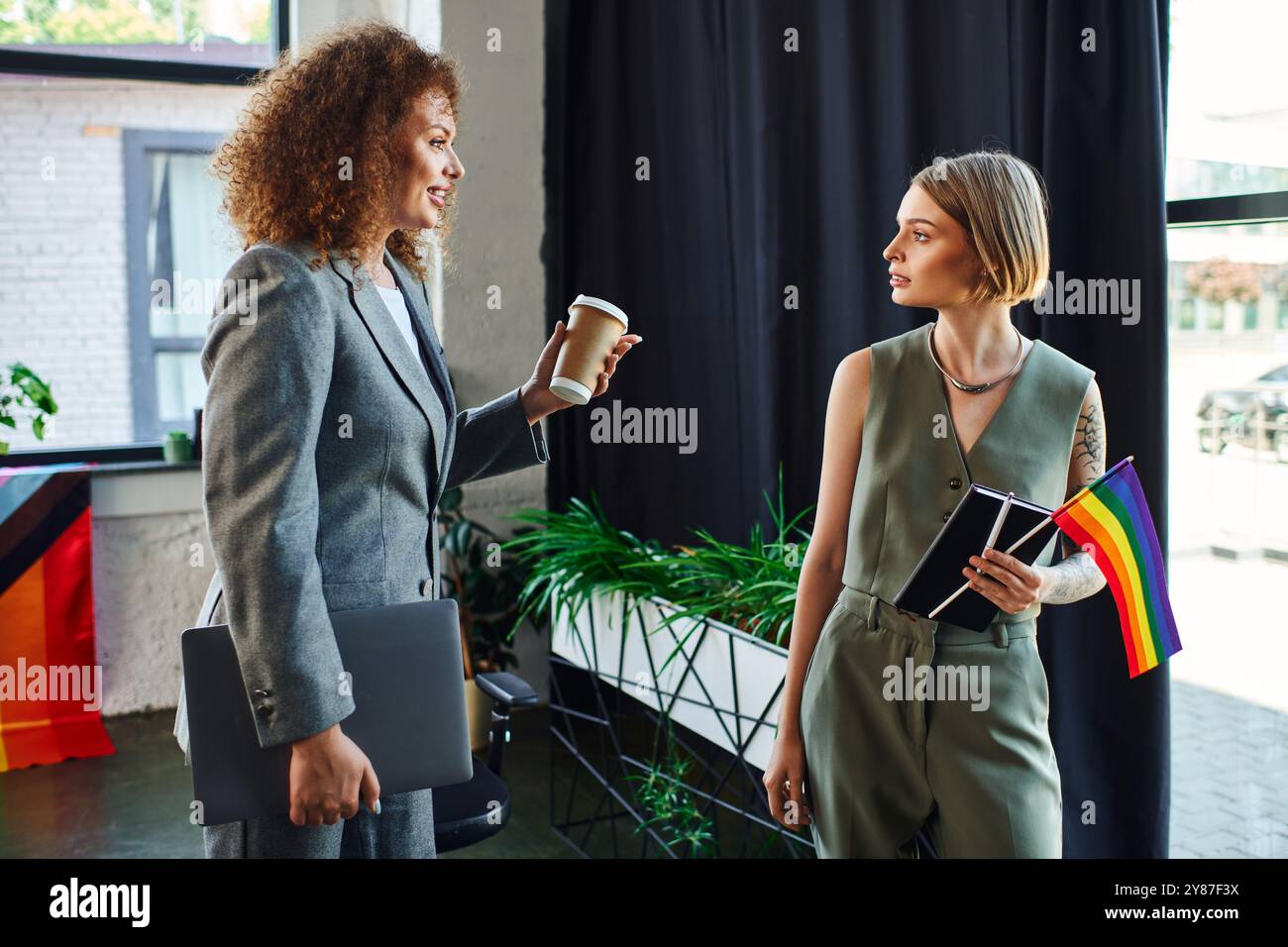 Zwei Kollegen führen ein inspirierendes Gespräch und fördern gleichzeitig den Stolz und die Einheit der LGBTQ. Stockfoto