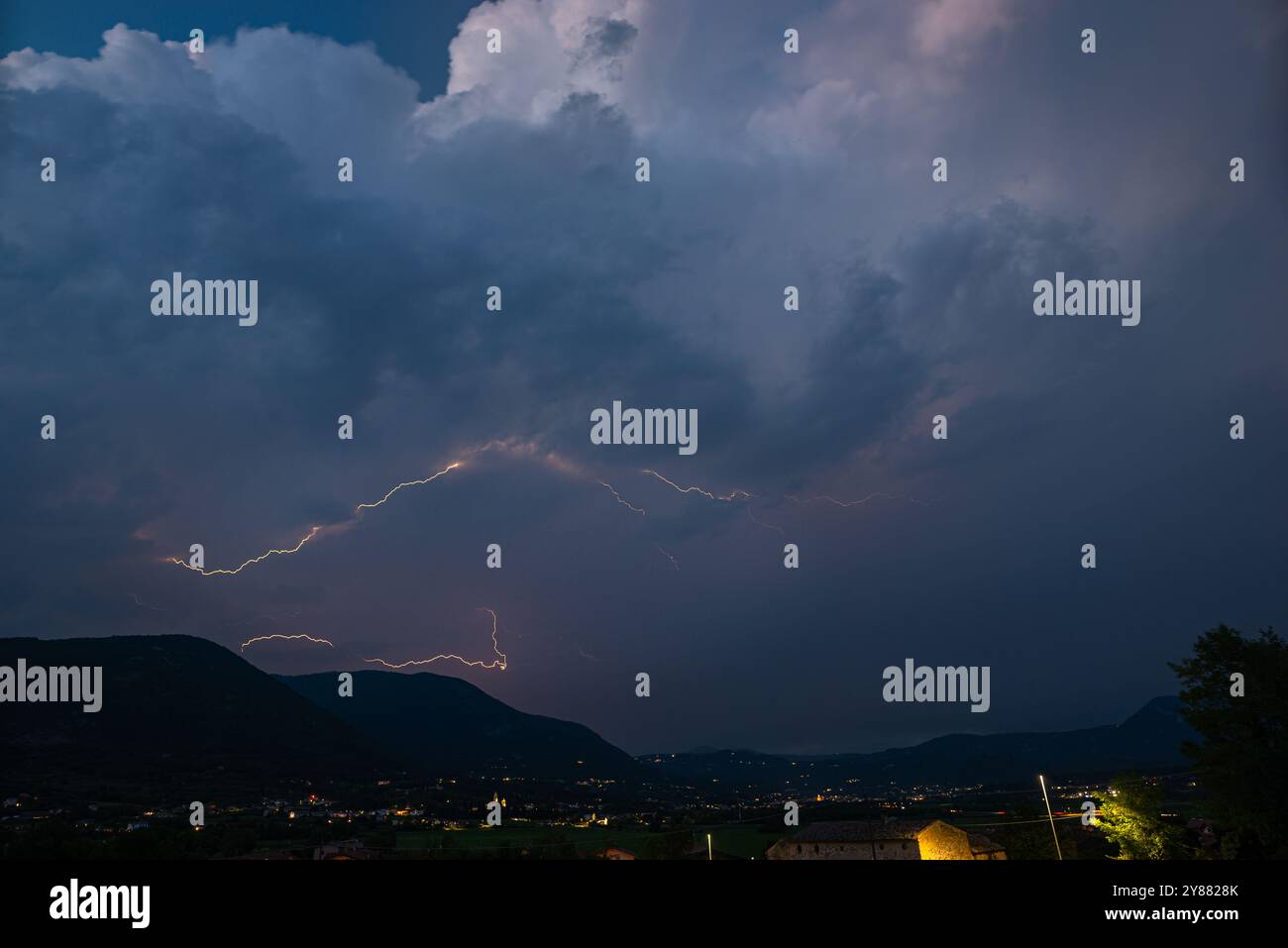 Gewitter mit Blitz über den italienischen Alpen in der Nähe der kleinen Stadt Caprino Veronese, nördlich von Verona, Italien Stockfoto