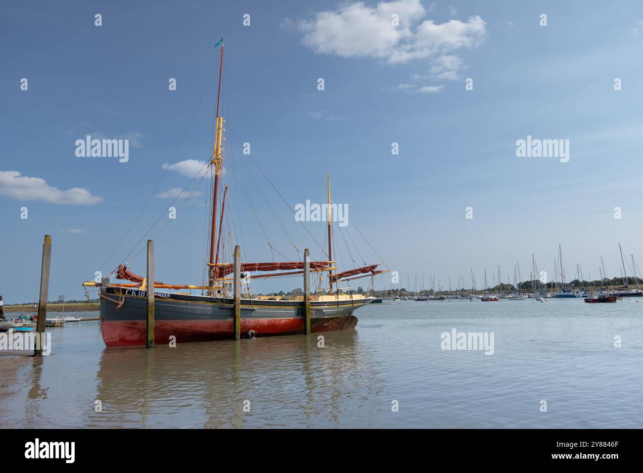 Themse Segelkahn Pioneer on Hard in Brightlingsea, dessen Rumpf bei Ebbe gereinigt wurde. Mit seinem klassischen Zärtchen im Vordergrund. Stockfoto