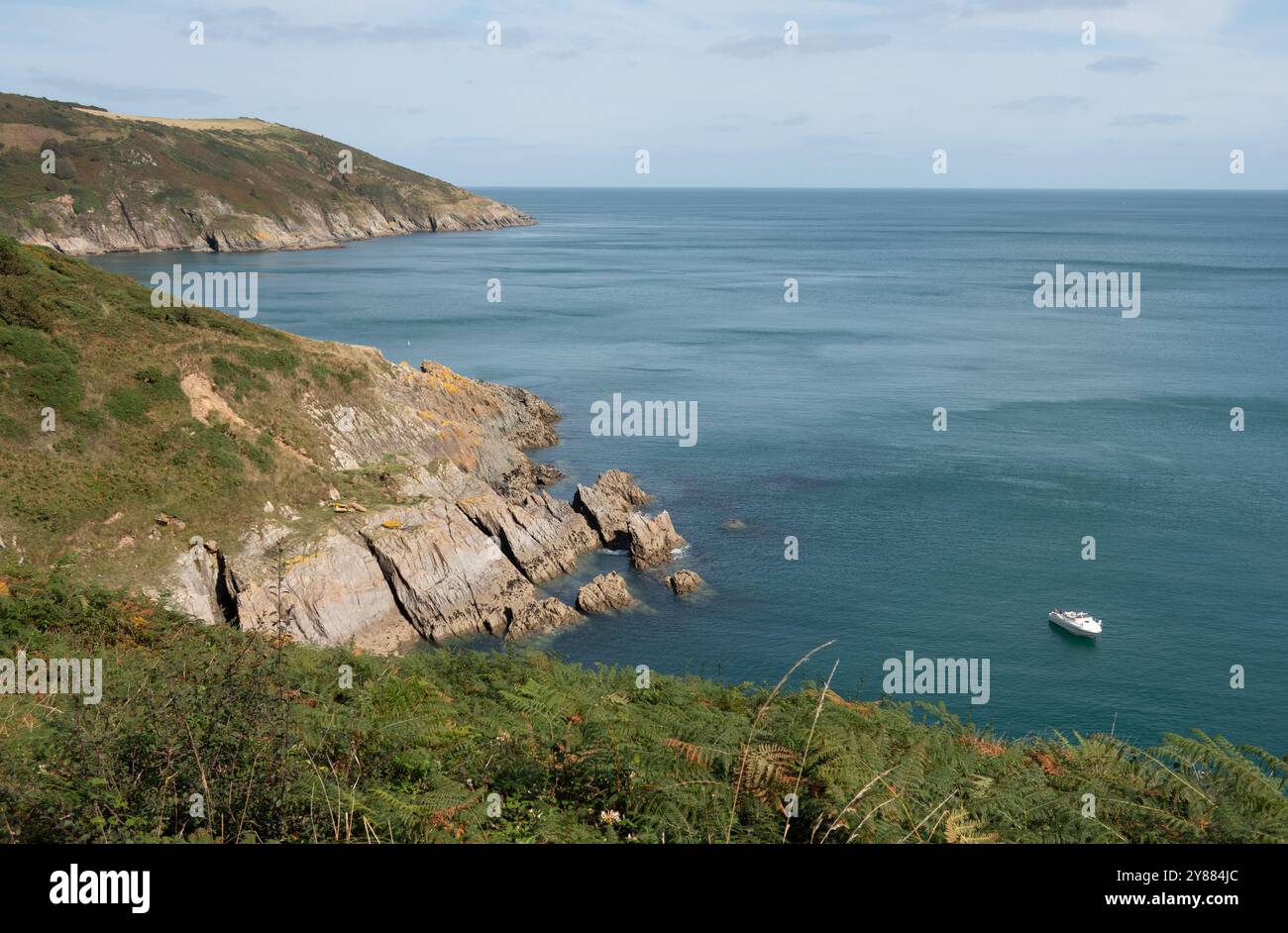 Küste von South Devon mit ruhigen Klippen und einem vertäuten Boot Stockfoto