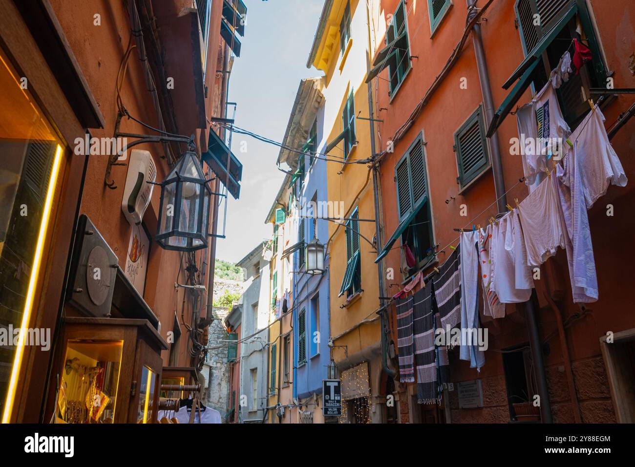 Klassischer italienischer Blick auf Wäschetrockner in einer engen Stadtstraße. Portovenere, Italien. Stockfoto