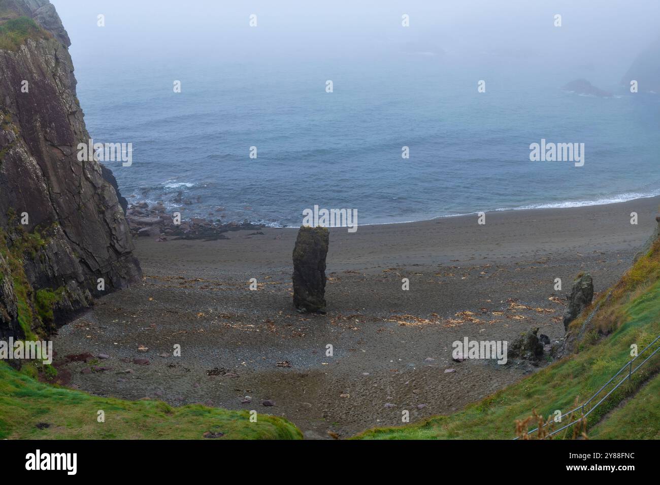 Nebelige Meereslandschaft am Strand Trá-na-mBó, Bunmahon, Irland – ruhige Strandszene mit Rocky Shores und sanften Wellen Stockfoto