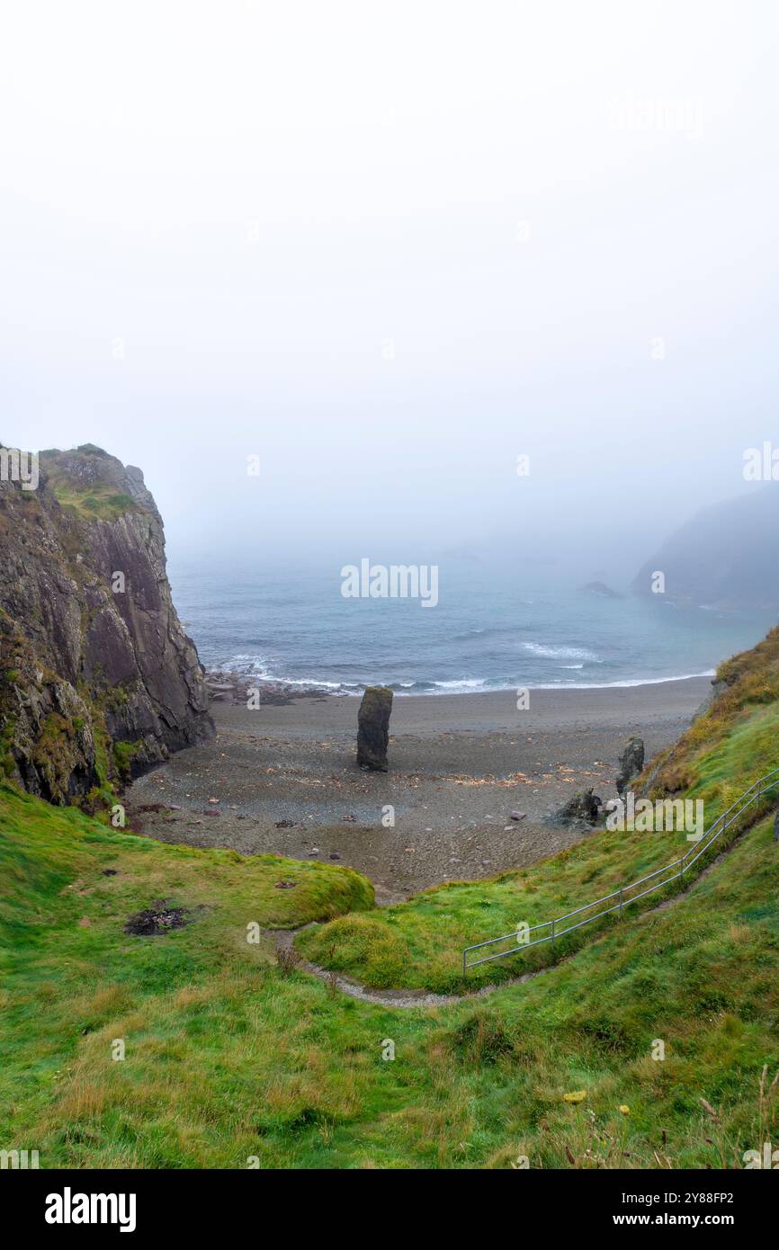 Nebelige Meereslandschaft am Strand Trá-na-mBó, Bunmahon, Irland – ruhige Strandszene mit Rocky Shores und sanften Wellen Stockfoto