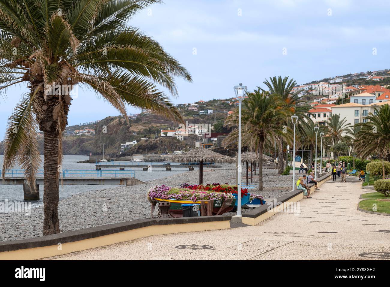 Die Leute laufen entlang des Strandes in der Stadt Santa Cruz auf Madeira. Stockfoto