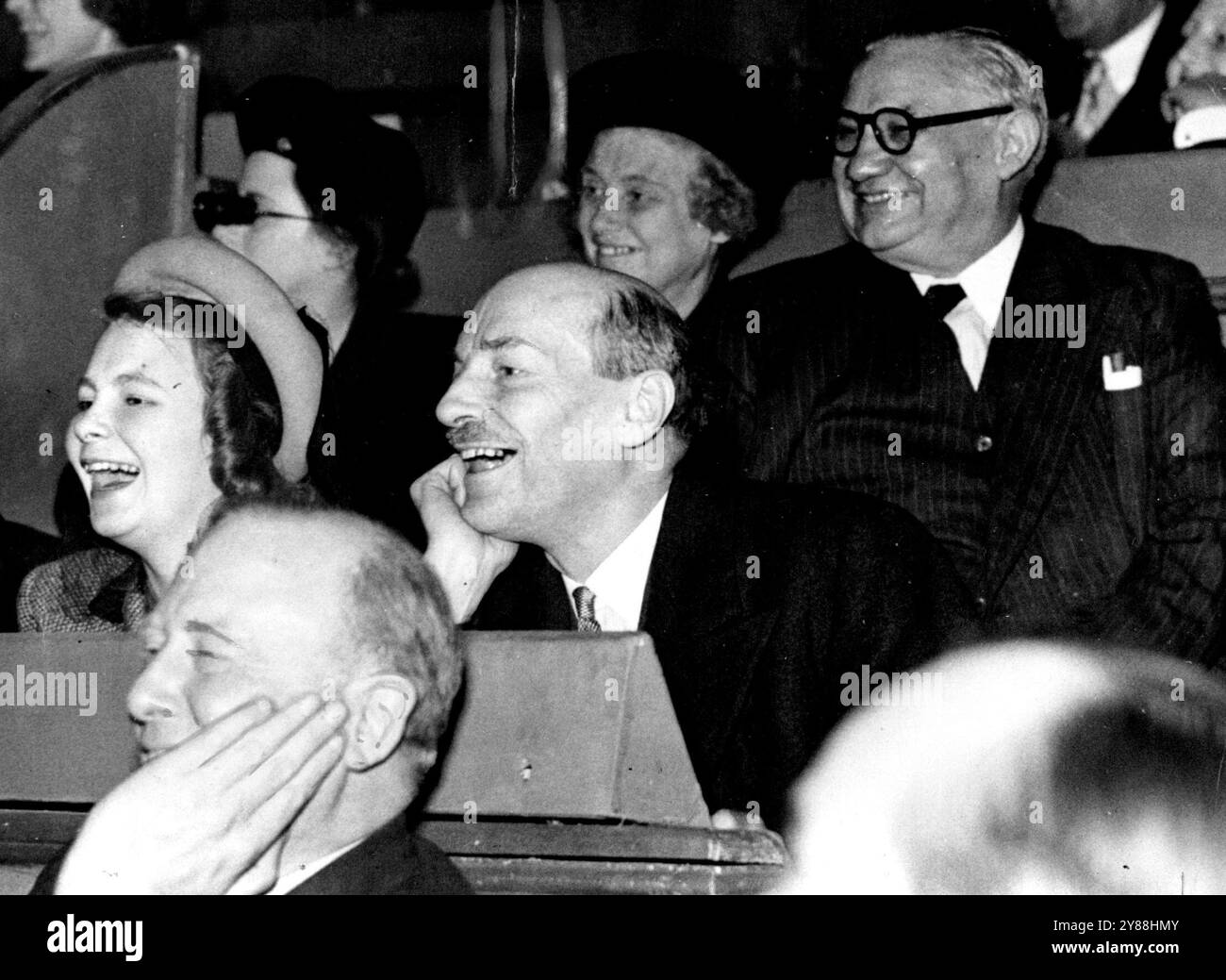 Eine Kabinettänderung. - Attlee, Bevin, vergiss die staatlichen Sorgen am Olympischen Zirkus -- Mr. Clement Attlee und seine Tochter Allison (links) mit Mr. Ernest Bevin war sehr amüsiert als die Mätzchen der Clowns während der Zirkusvorstellung. Der britische Premierminister nahm seine jüngere Tochter Allison zum Weihnachtszirkus der Bertram Mills in Olympia, London Ernest Bevin, der britische Außenminister, war ebenfalls für eine kurze Pause von seinen mühsamen Aufgaben dort. Dezember 1947. Stockfoto